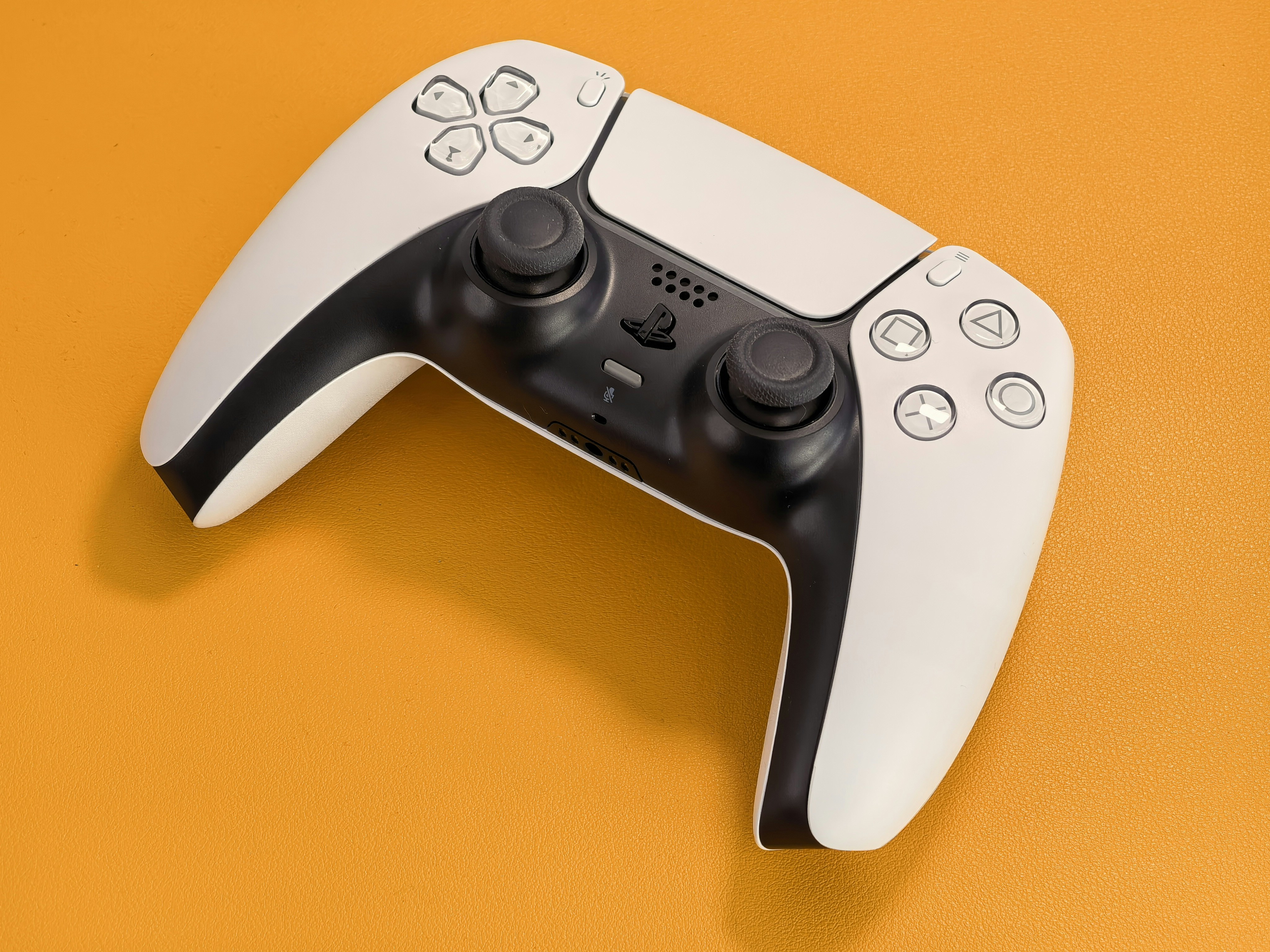 White video game controller on an orange background