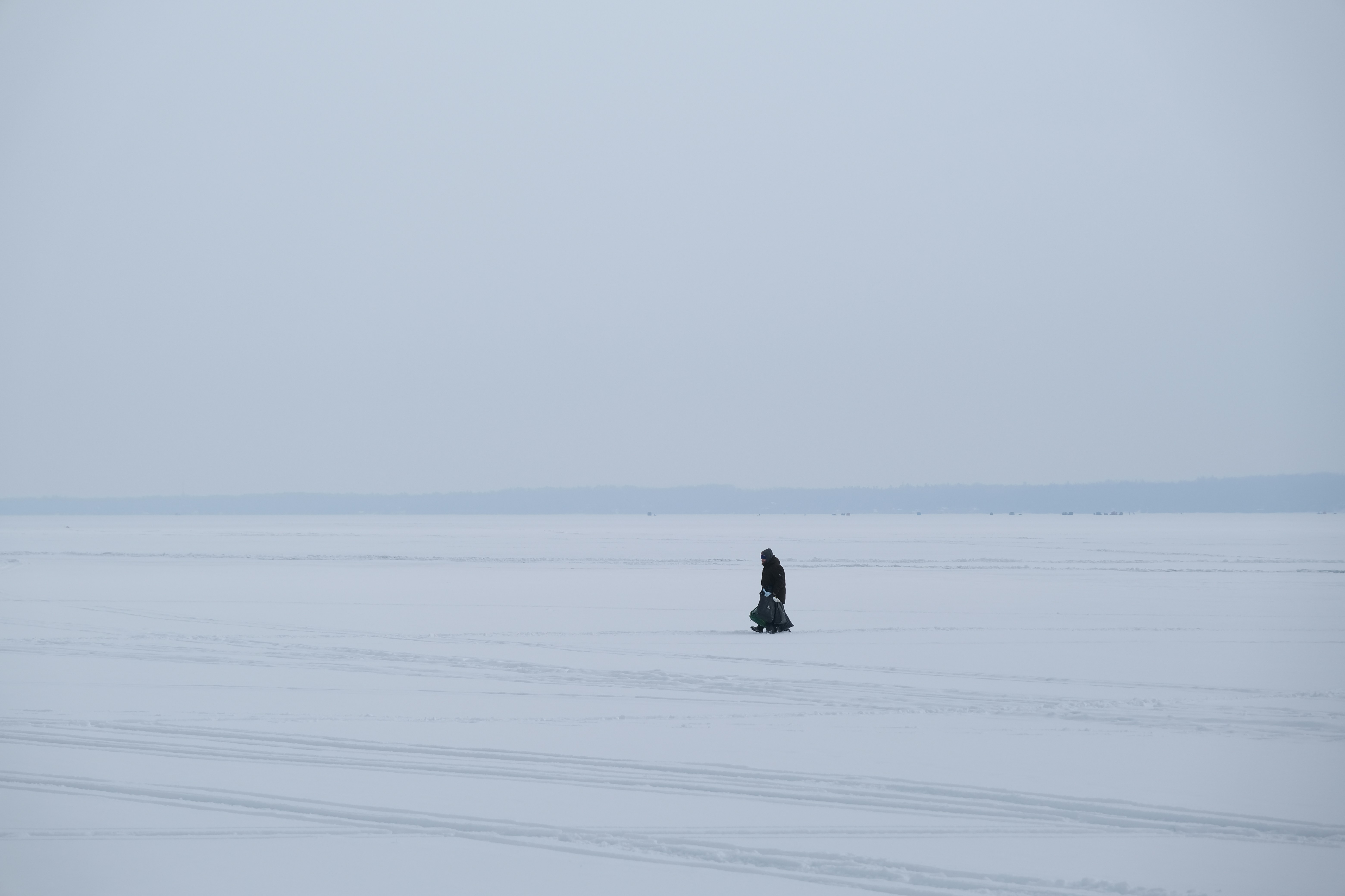 A lone figure stands on a vast, frozen expanse