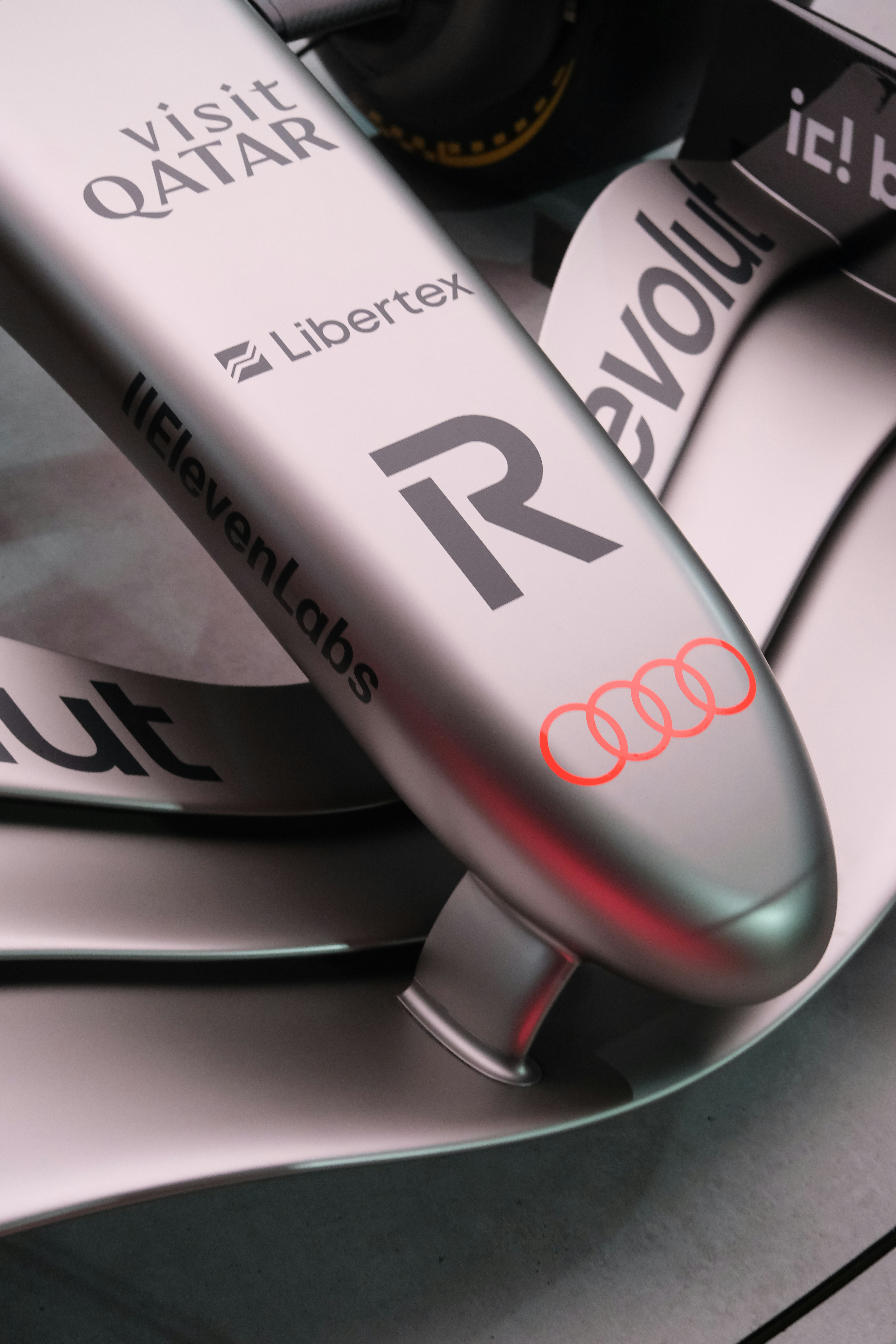 Silver race car with audi logo and sponsors.