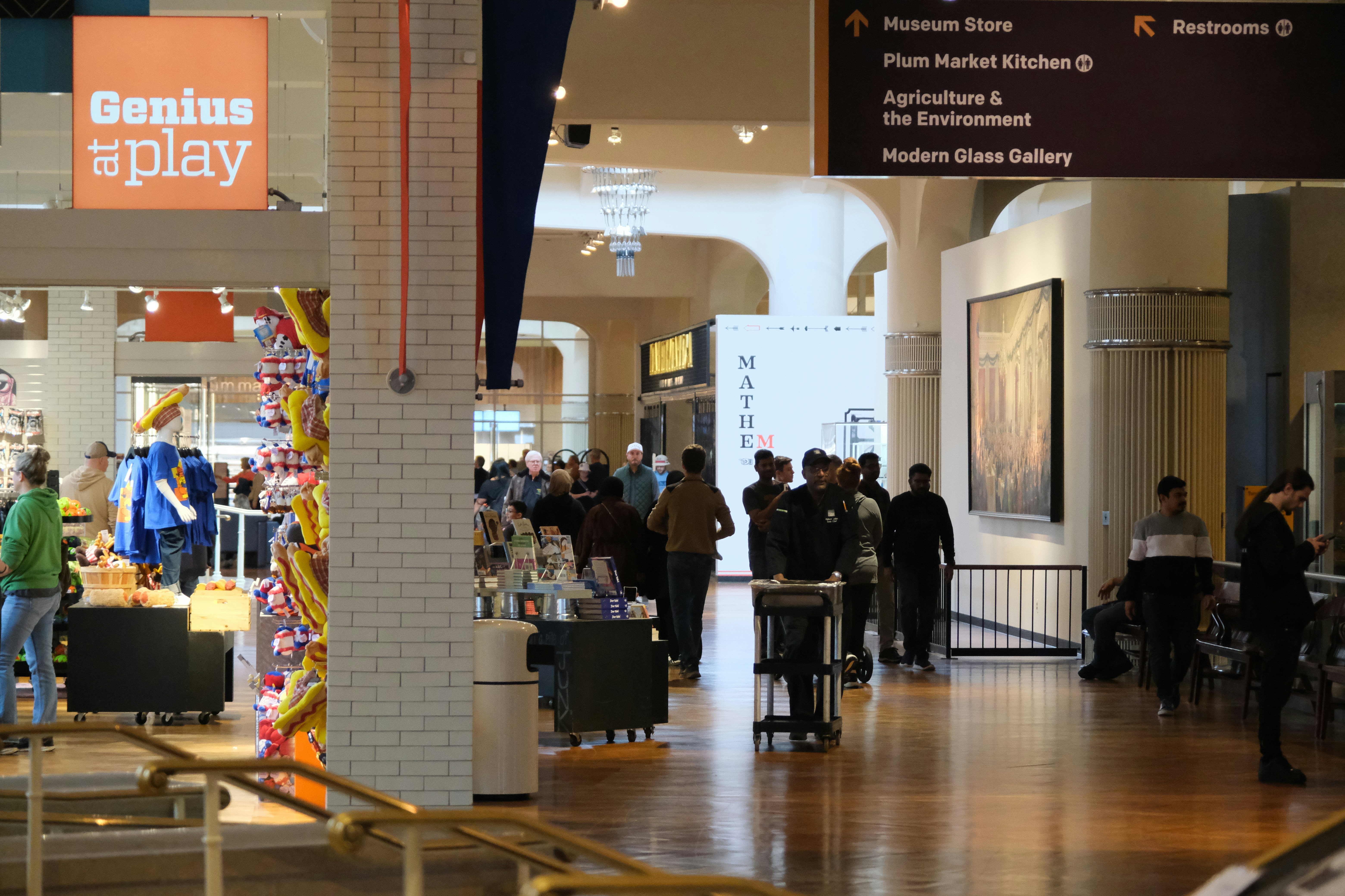 People walking through a museum hall with exhibits.