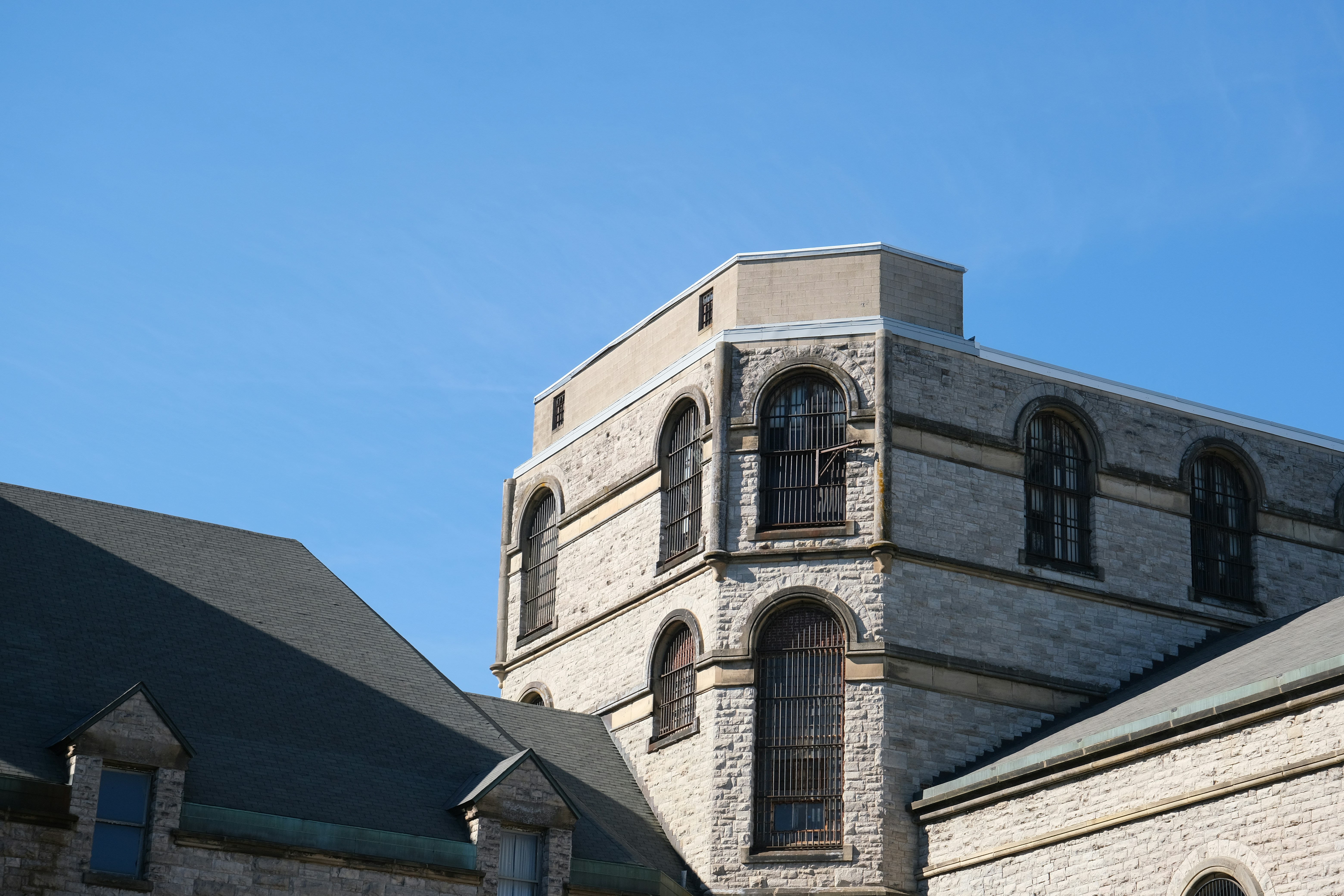 Stone building with arched windows against blue sky