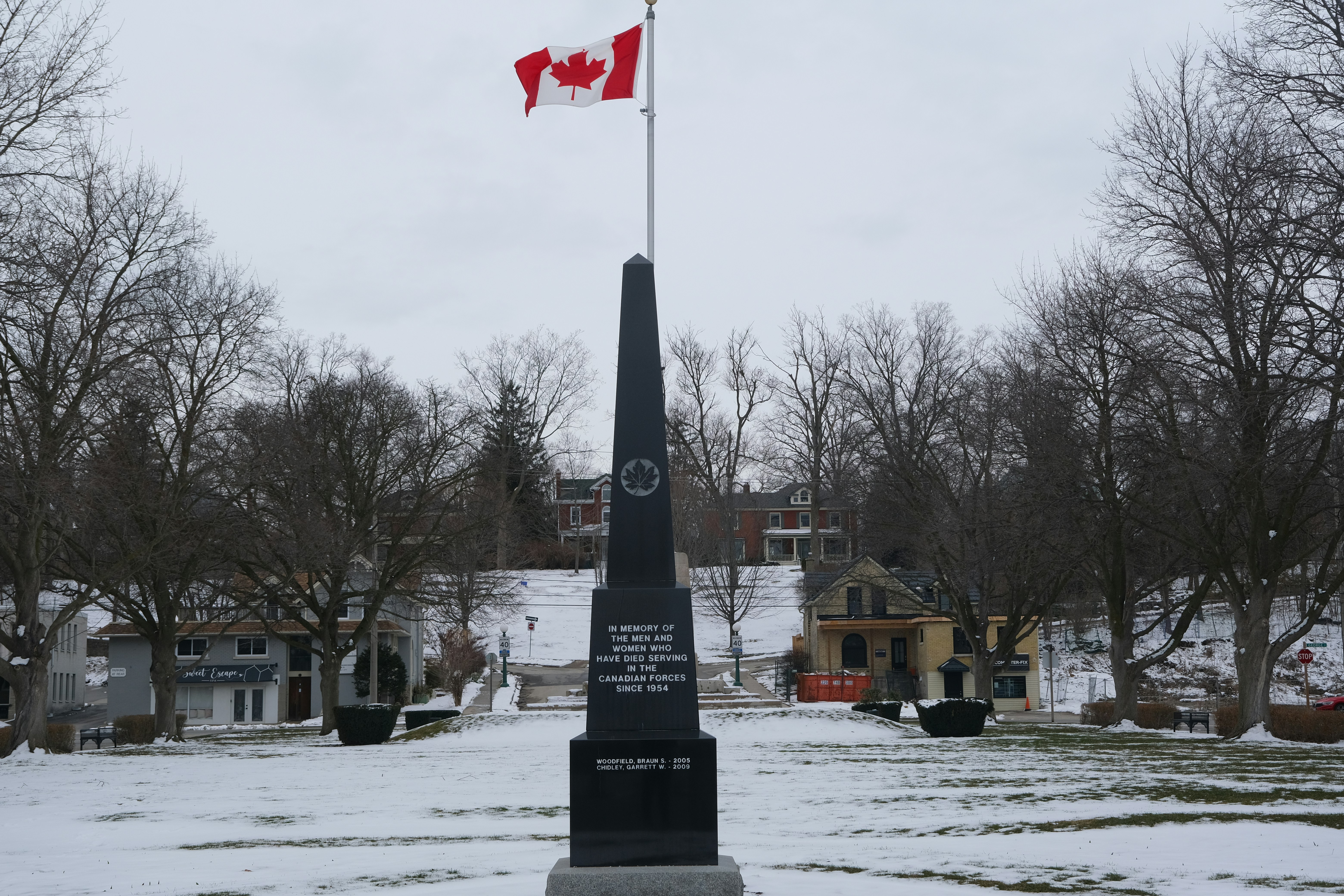 A monument with a canadian flag in winter