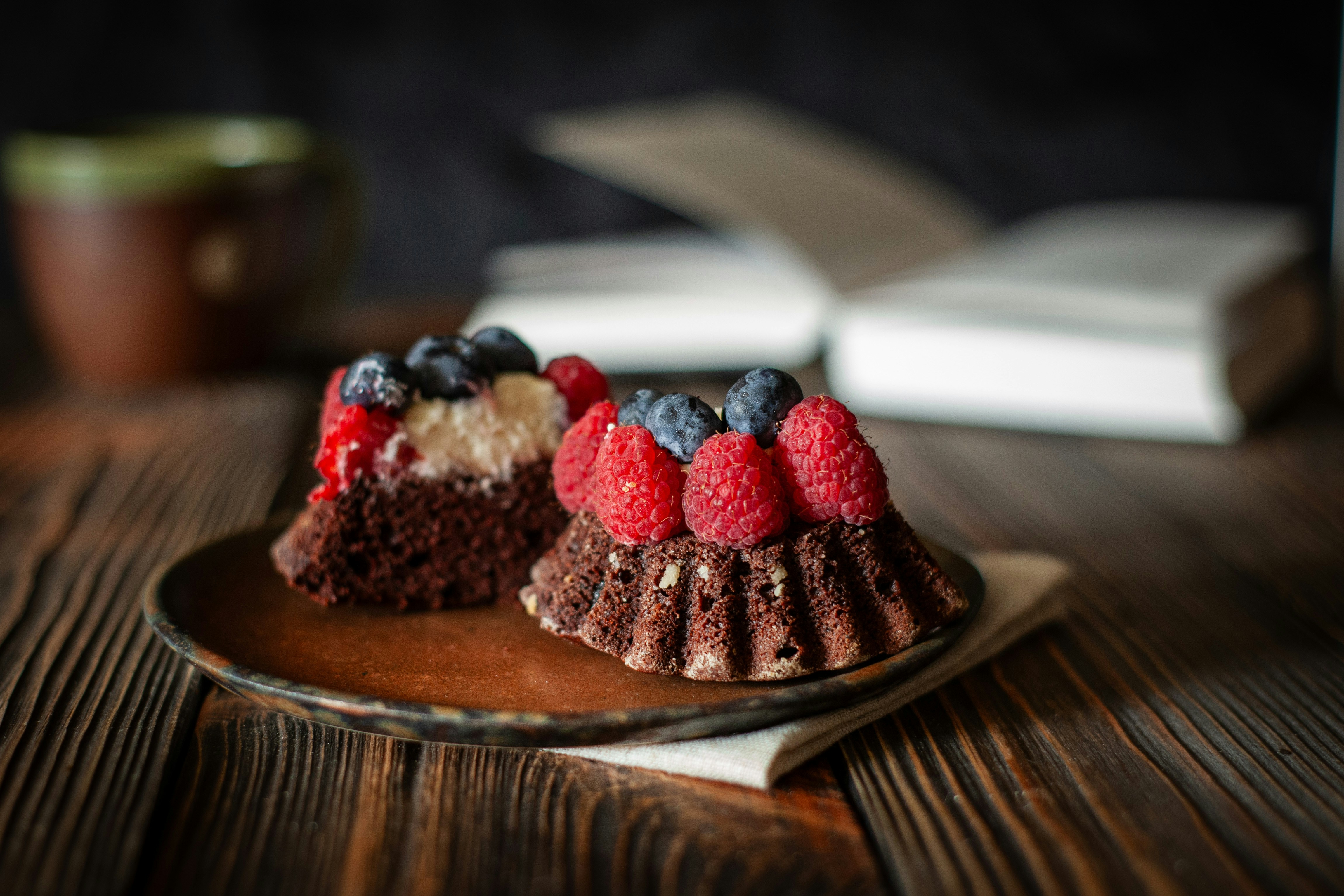 Dos pasteles de chocolate con frutos rojos en un plato.