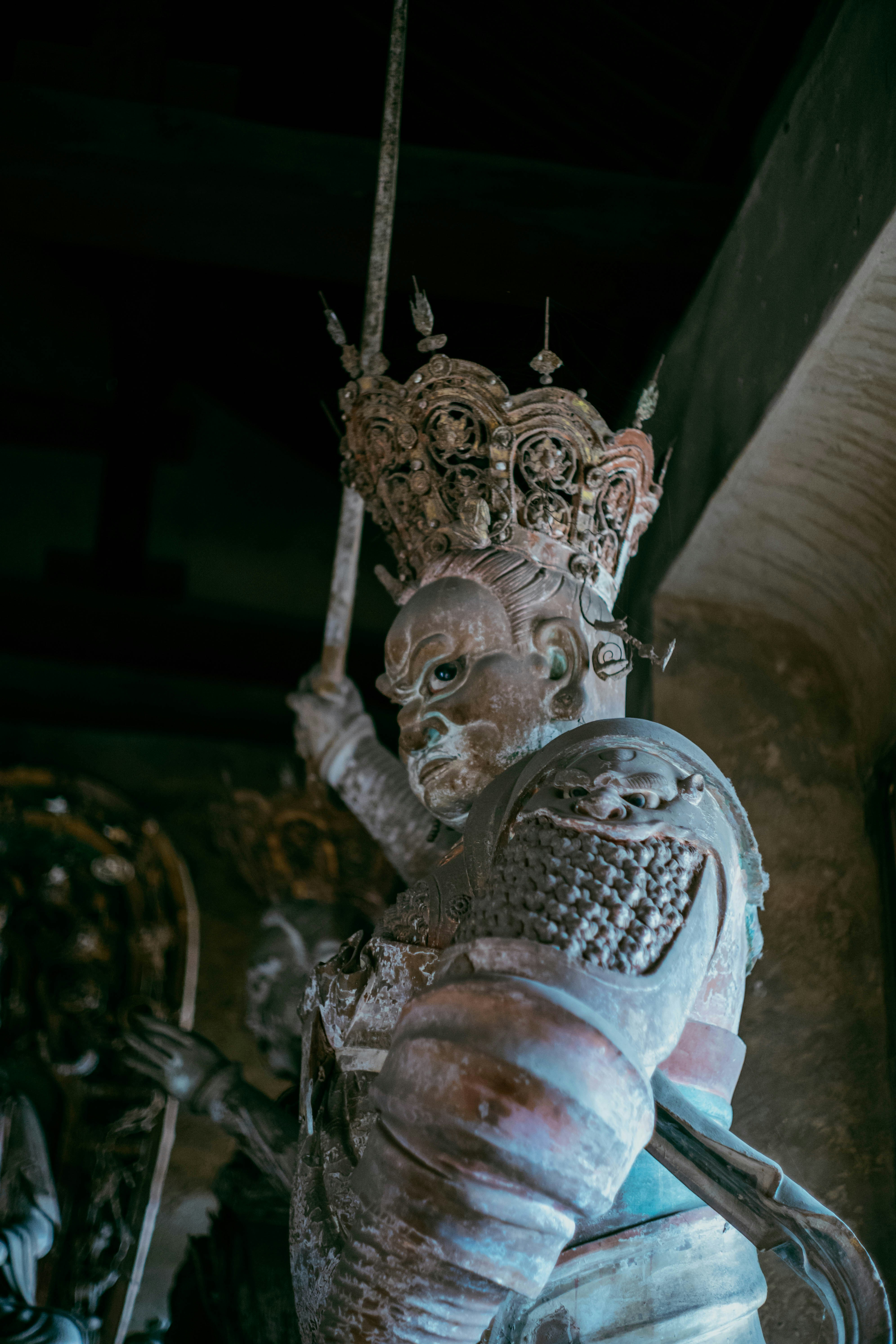 Statue de pierre d’un roi en armure tenant une épée