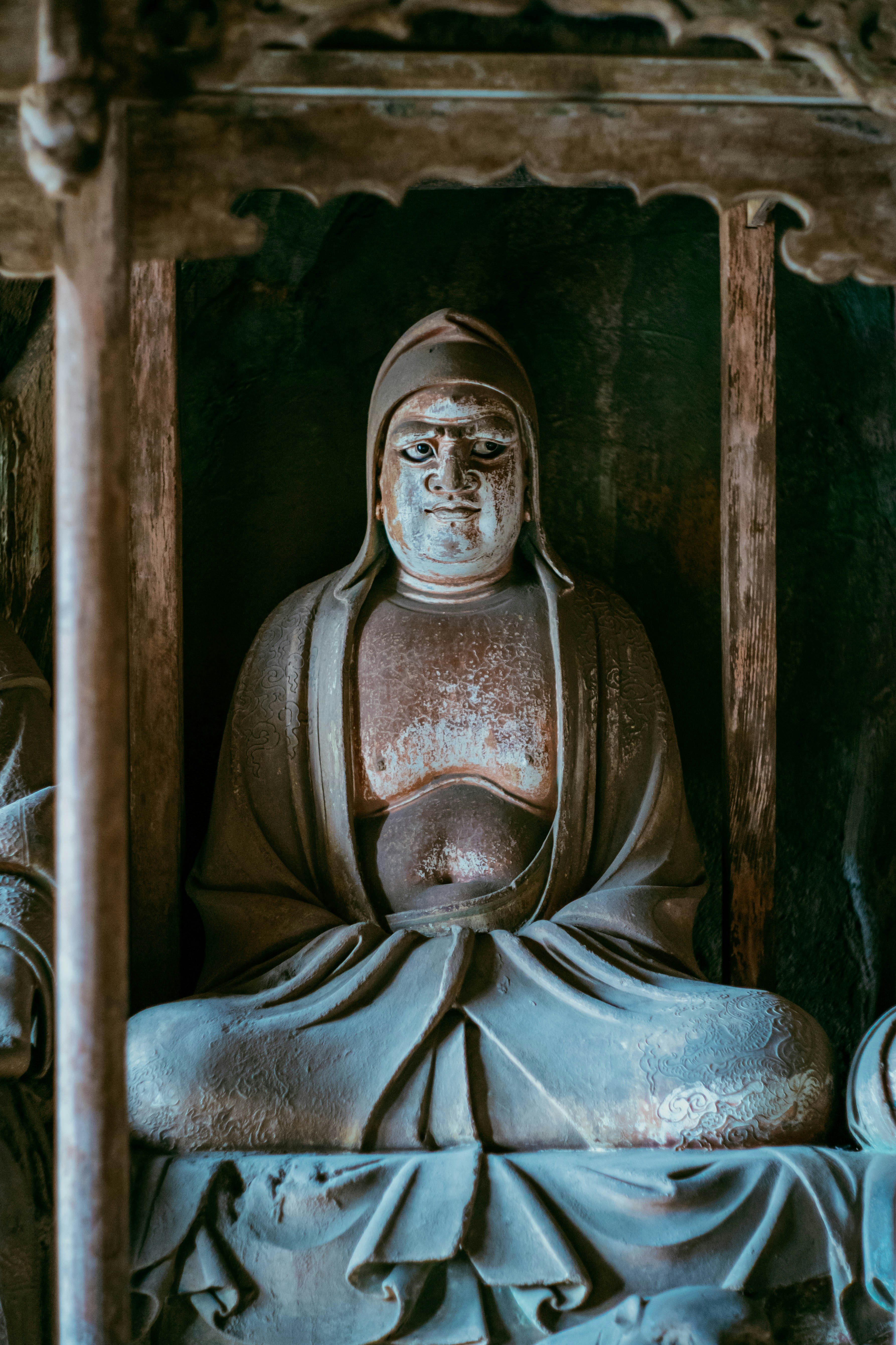 Steinstatue eines sitzenden Buddha in einem Schrein.