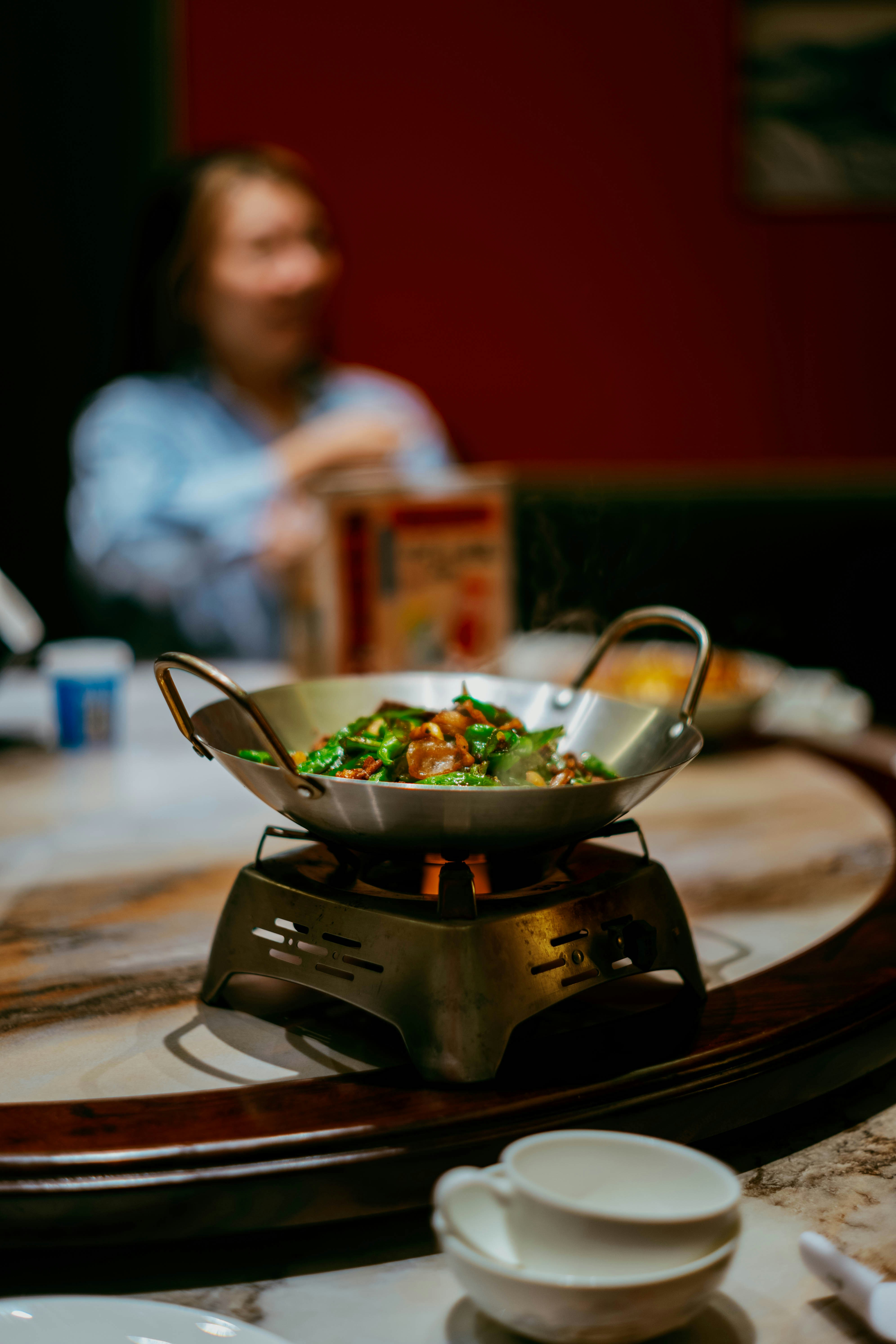 Comida caliente servida en un cuenco metálico sobre un fuego.