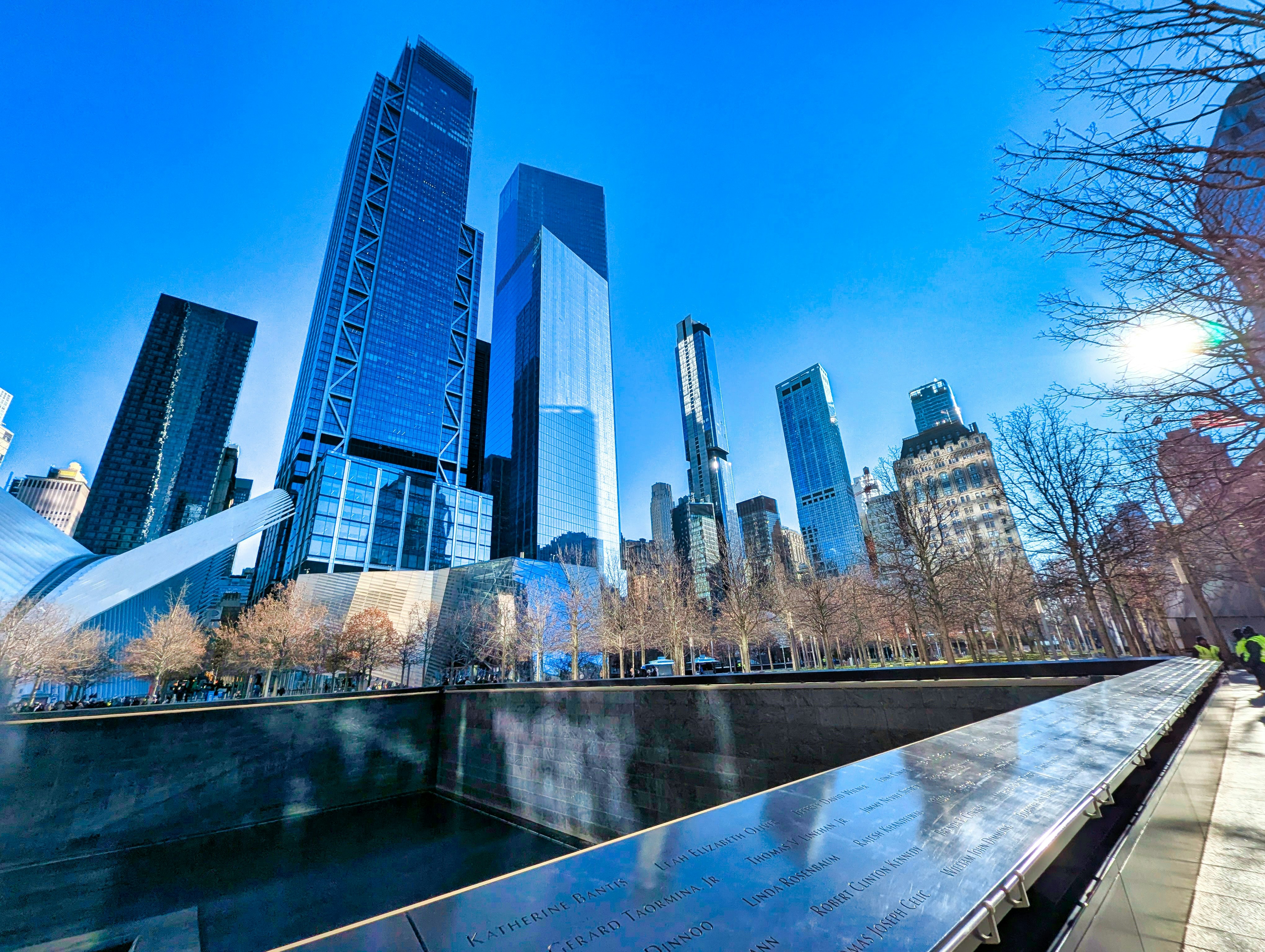 One World Trade Center rising above a reflecting pool at the 9/11 Memorial