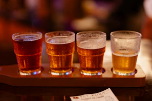 Four glasses of beer on a wooden tray