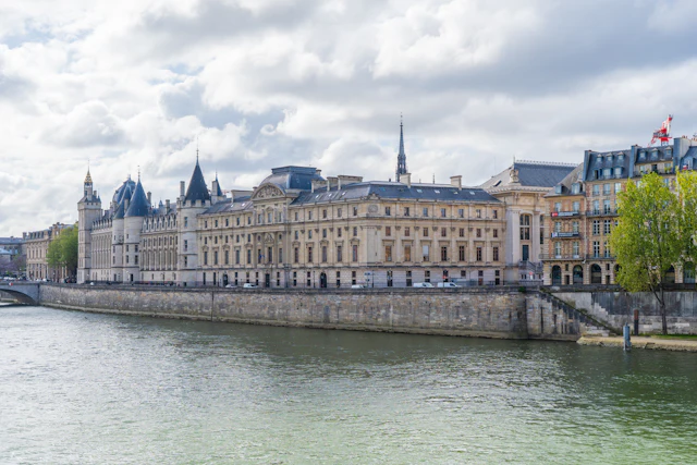 The Conciergerie's turreted riverside facade on Île de la Cité seen across the Seine