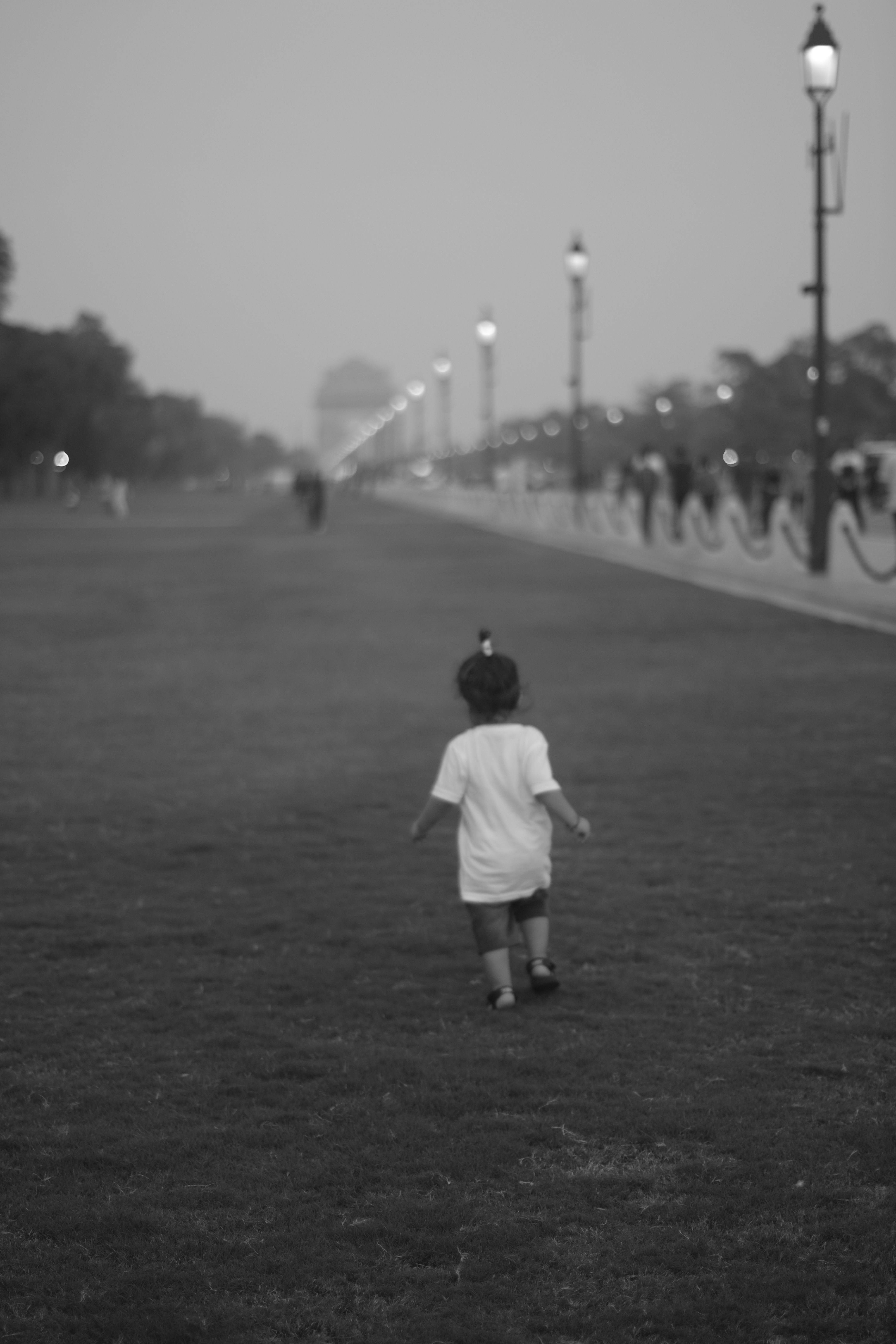 子供が一人で草の道を歩いている。