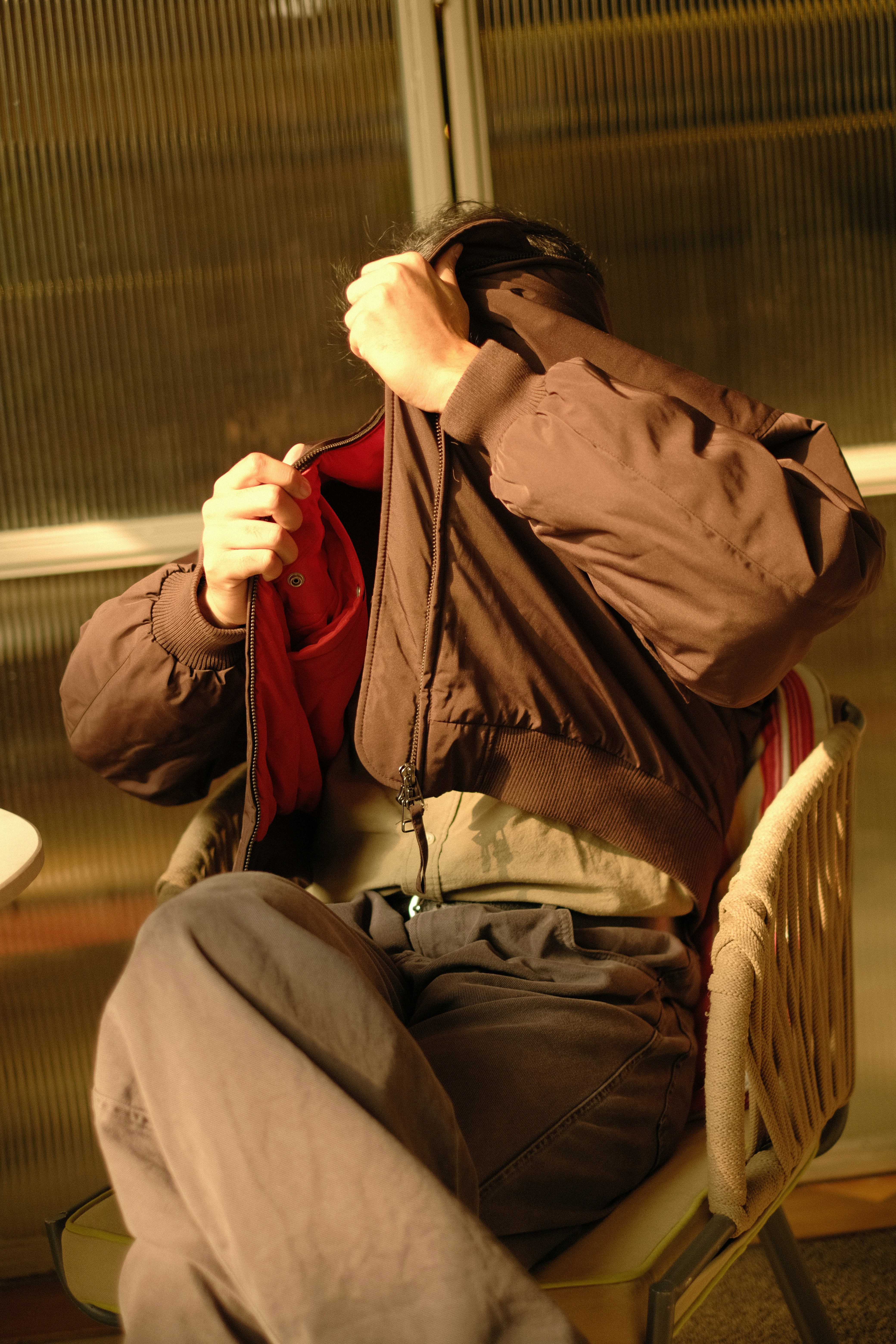 座ってジャケットのファスナーを上げている人