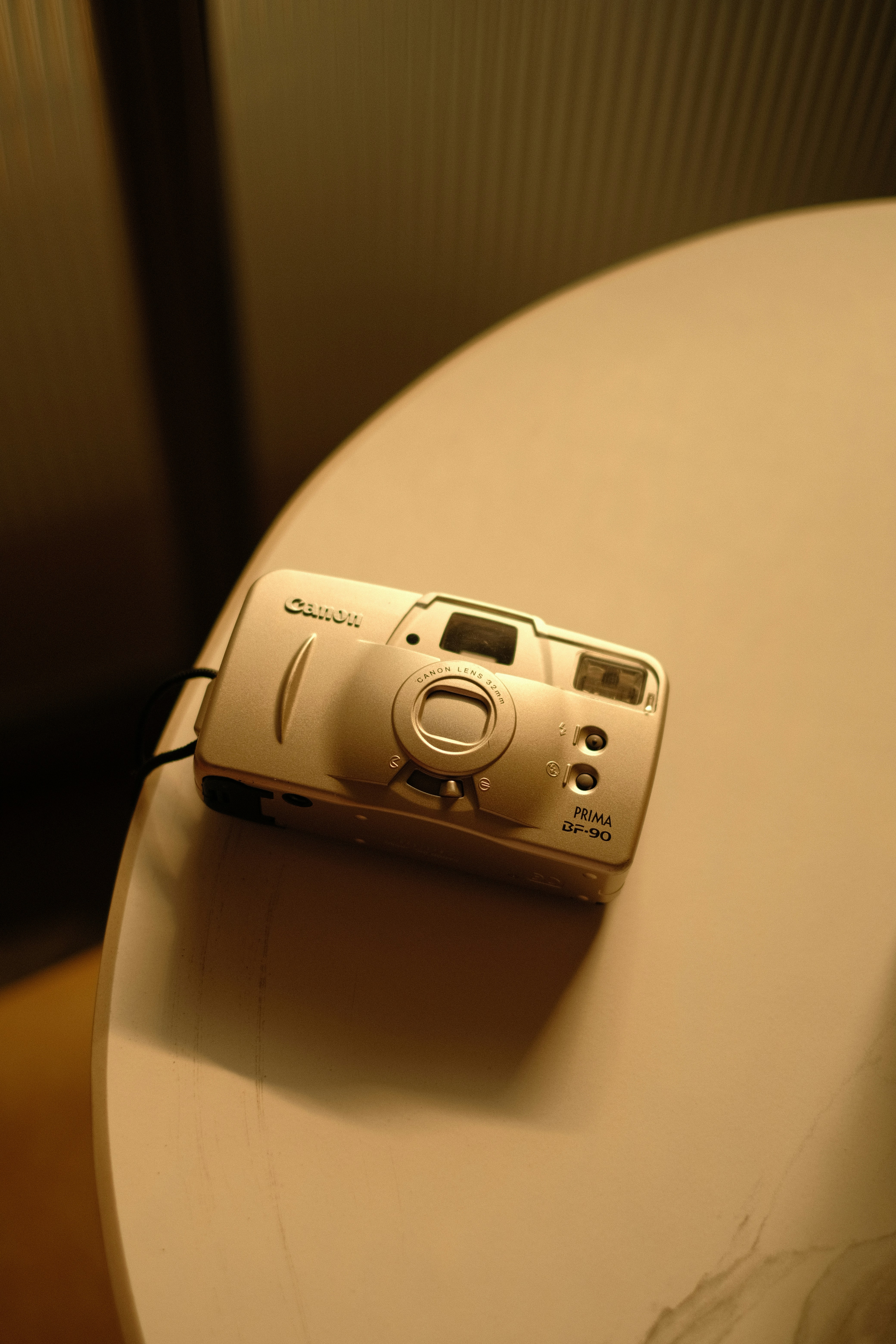 テーブルの上に置かれた銀色のCanonコンパクトカメラ。