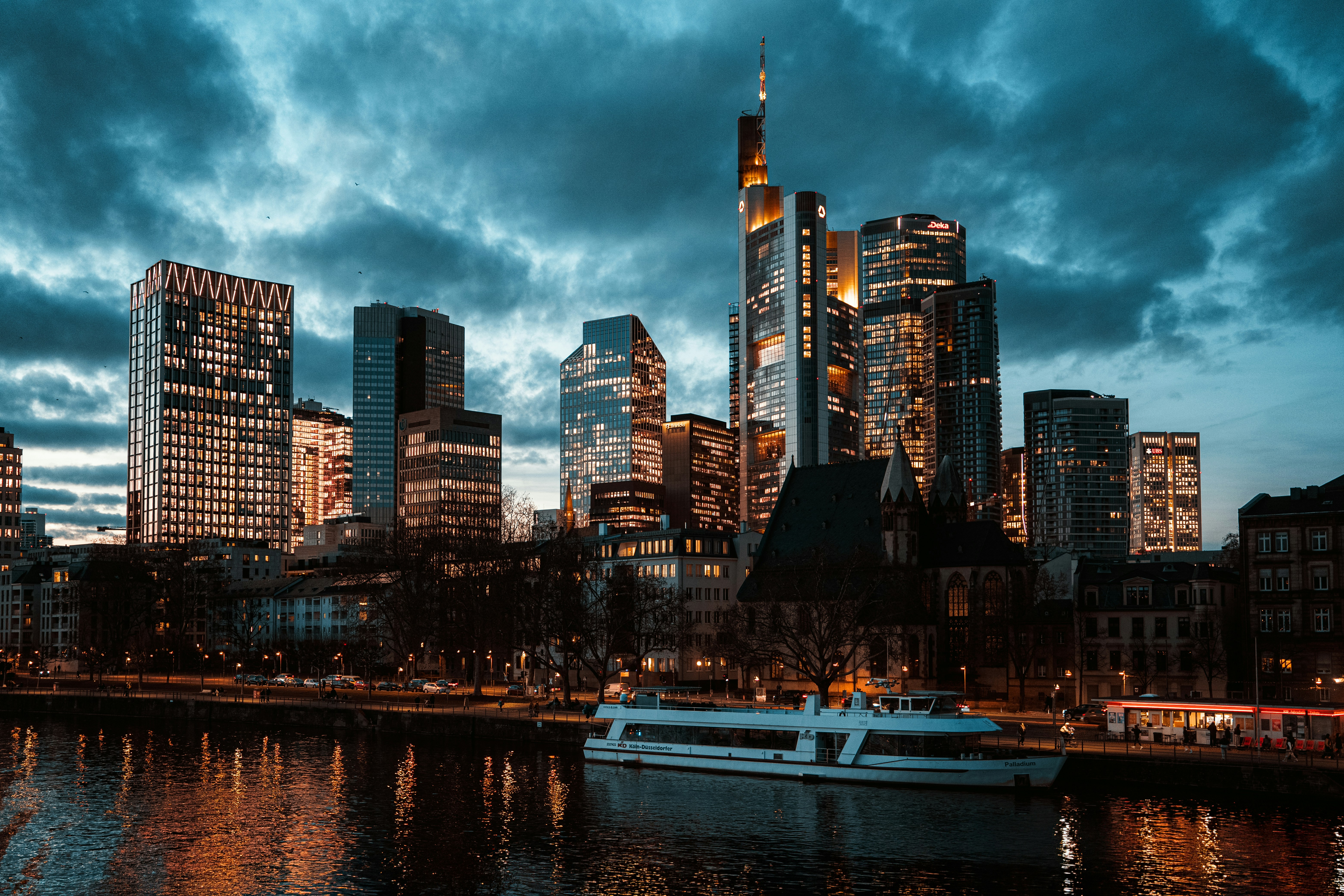 Modern cityscape with skyscrapers and river at dusk