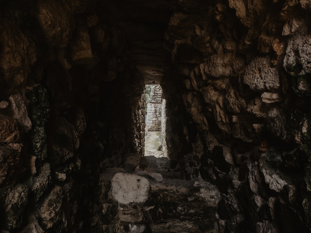 Dark stone tunnel with light at the end.