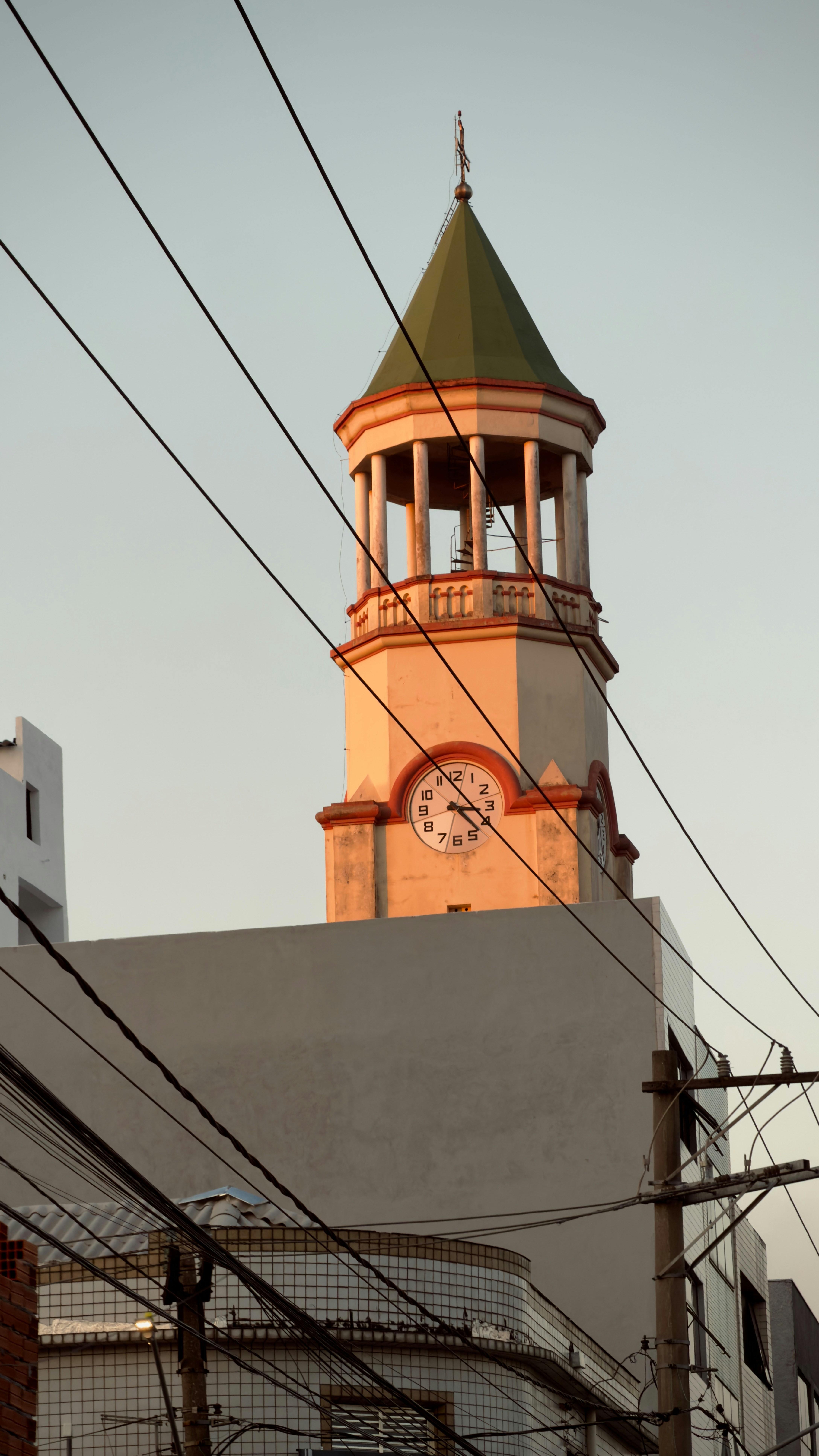 Torre do relógio com telhado verde e torre do sino.