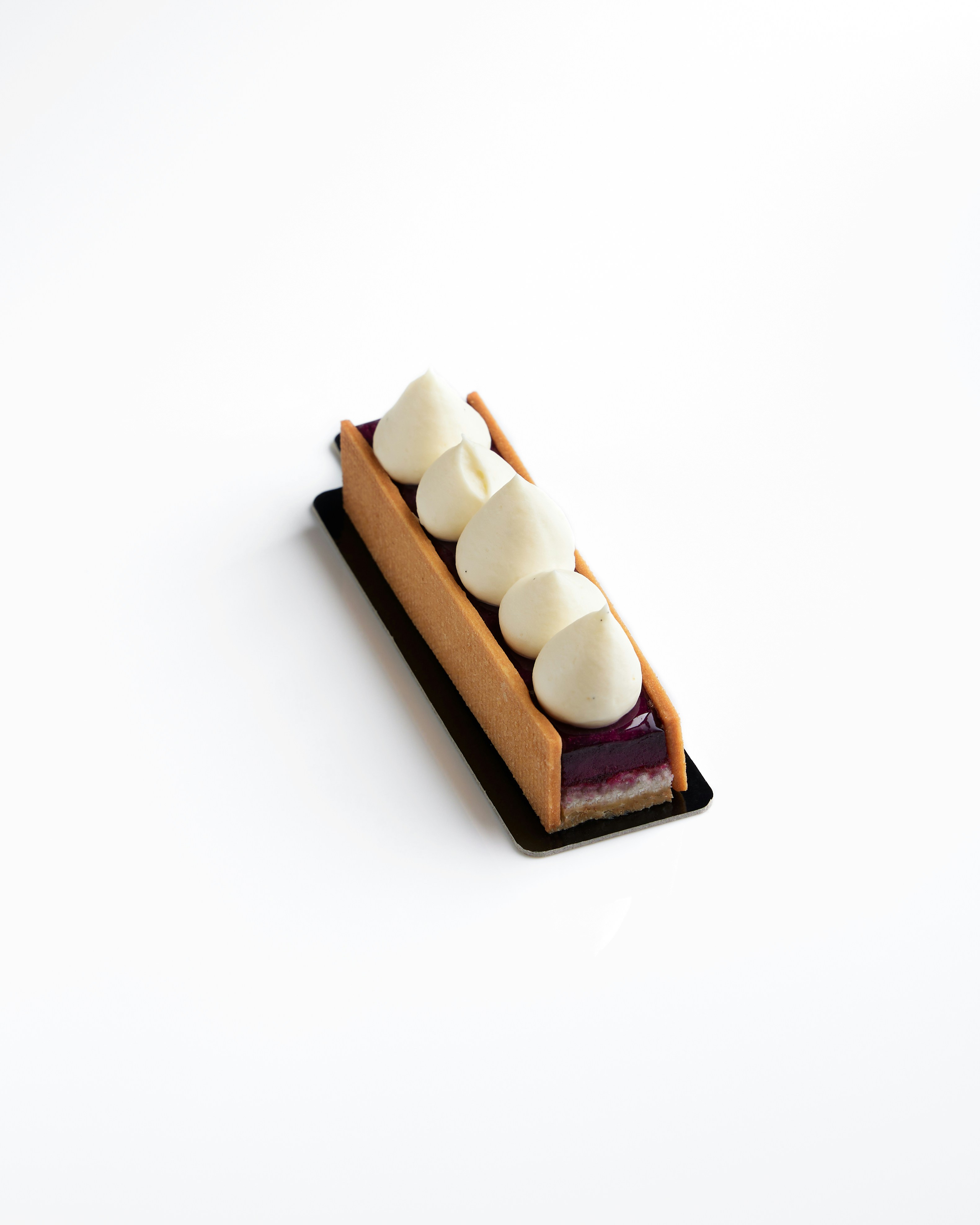 Pastel rectangular con relleno morado y nata montada