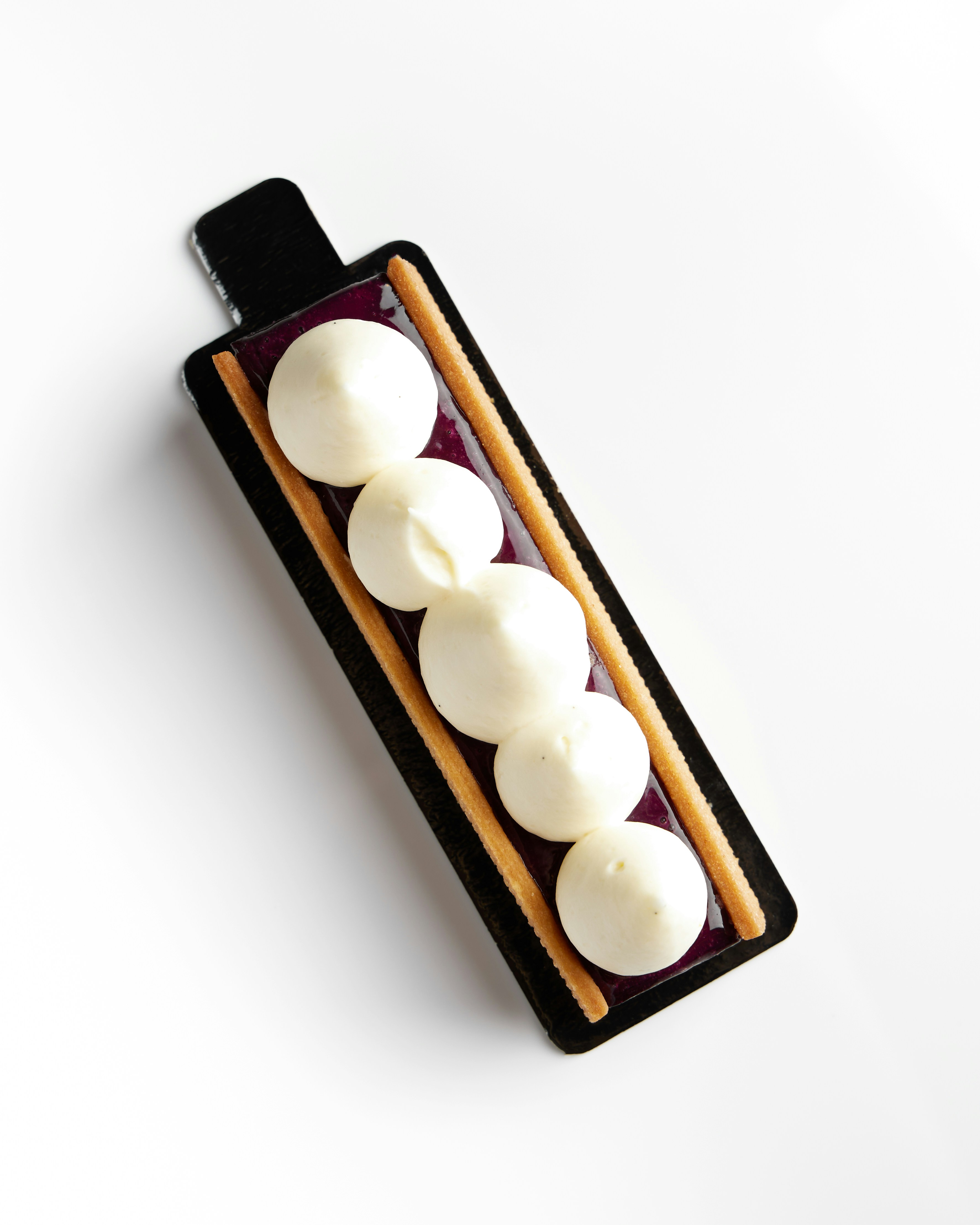 Postre rectangular con nata blanca y galletas
