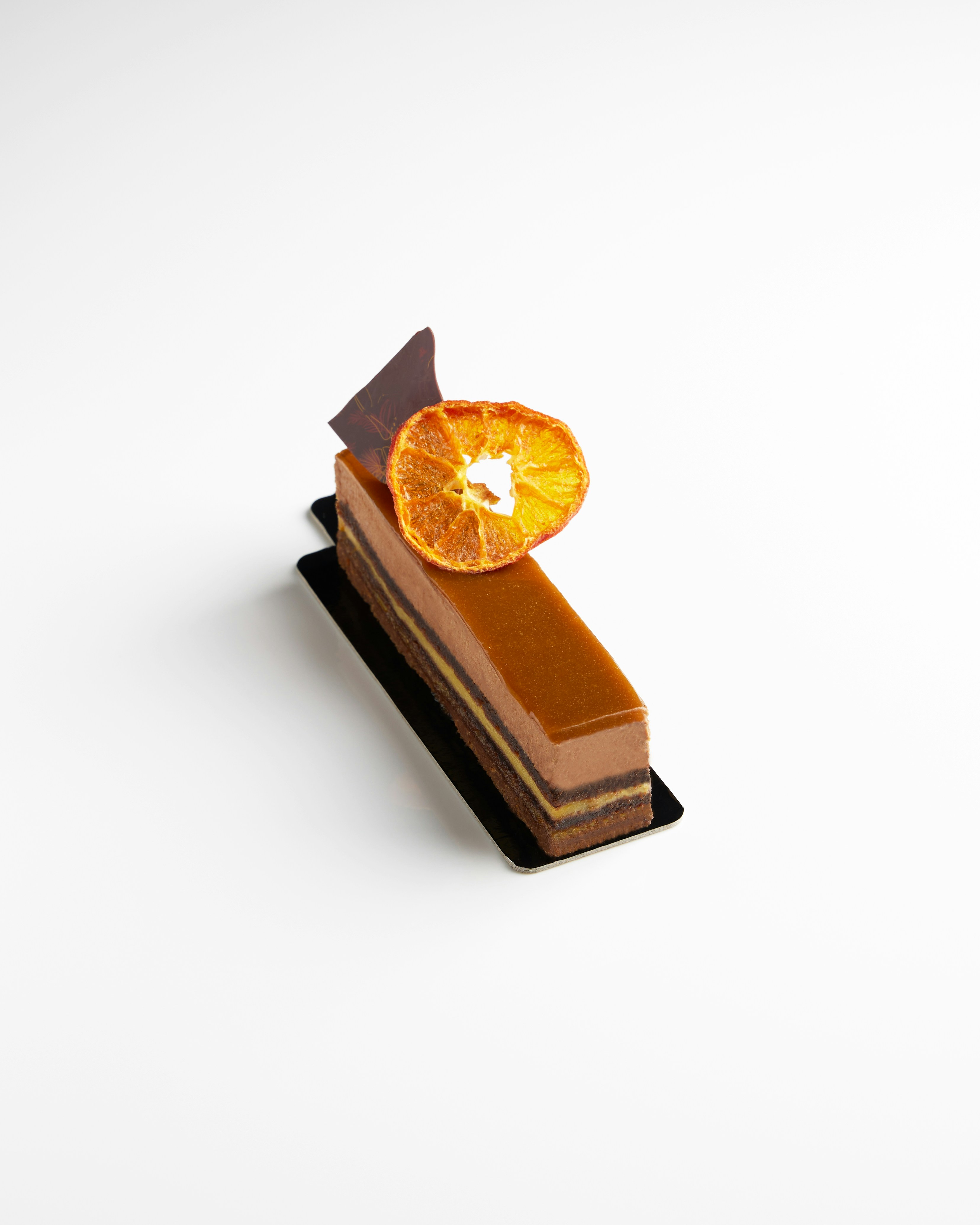 Postre gourmet de chocolate y naranja sobre fondo blanco