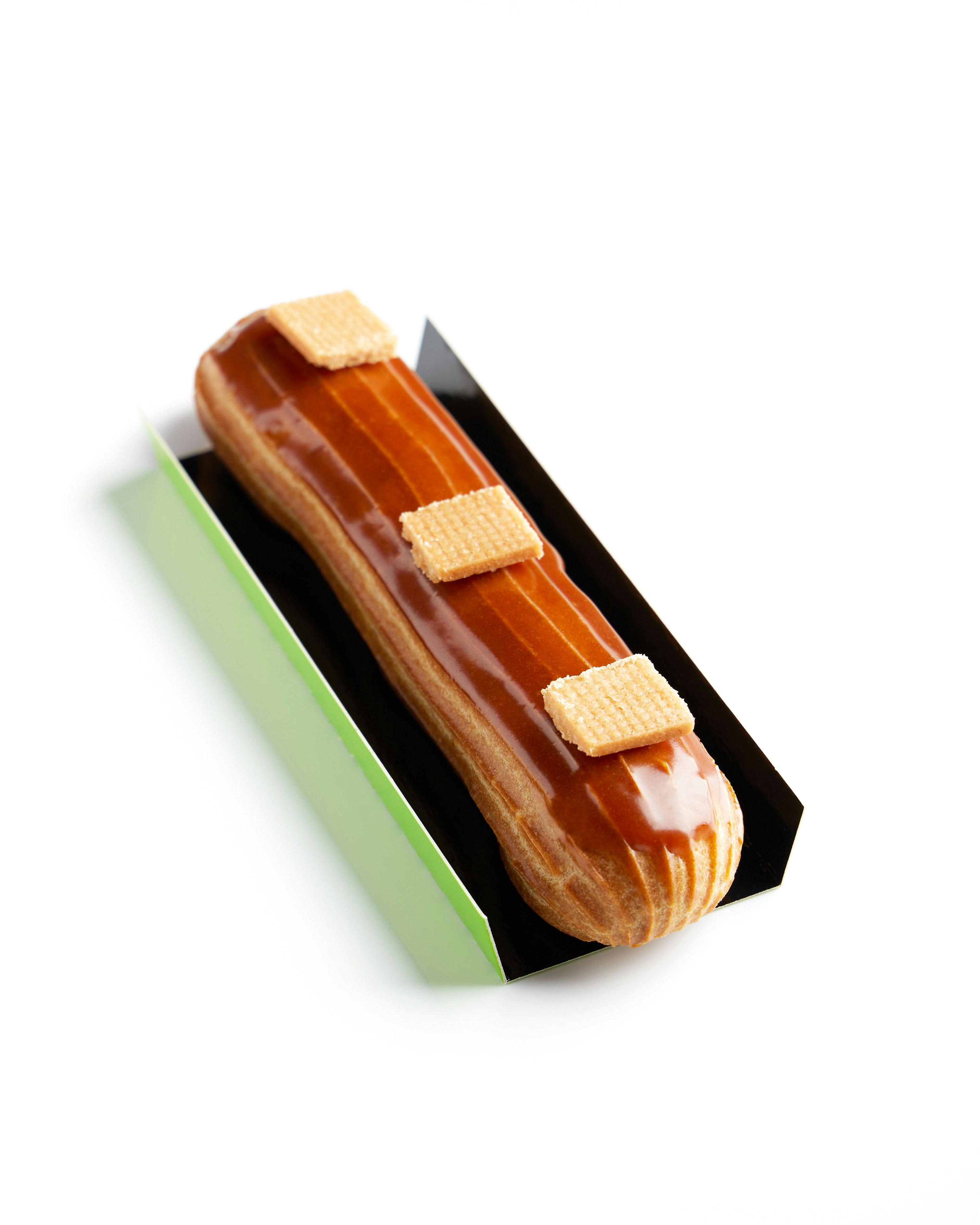 Un éclair de caramelo brillante coronado con tres galletas