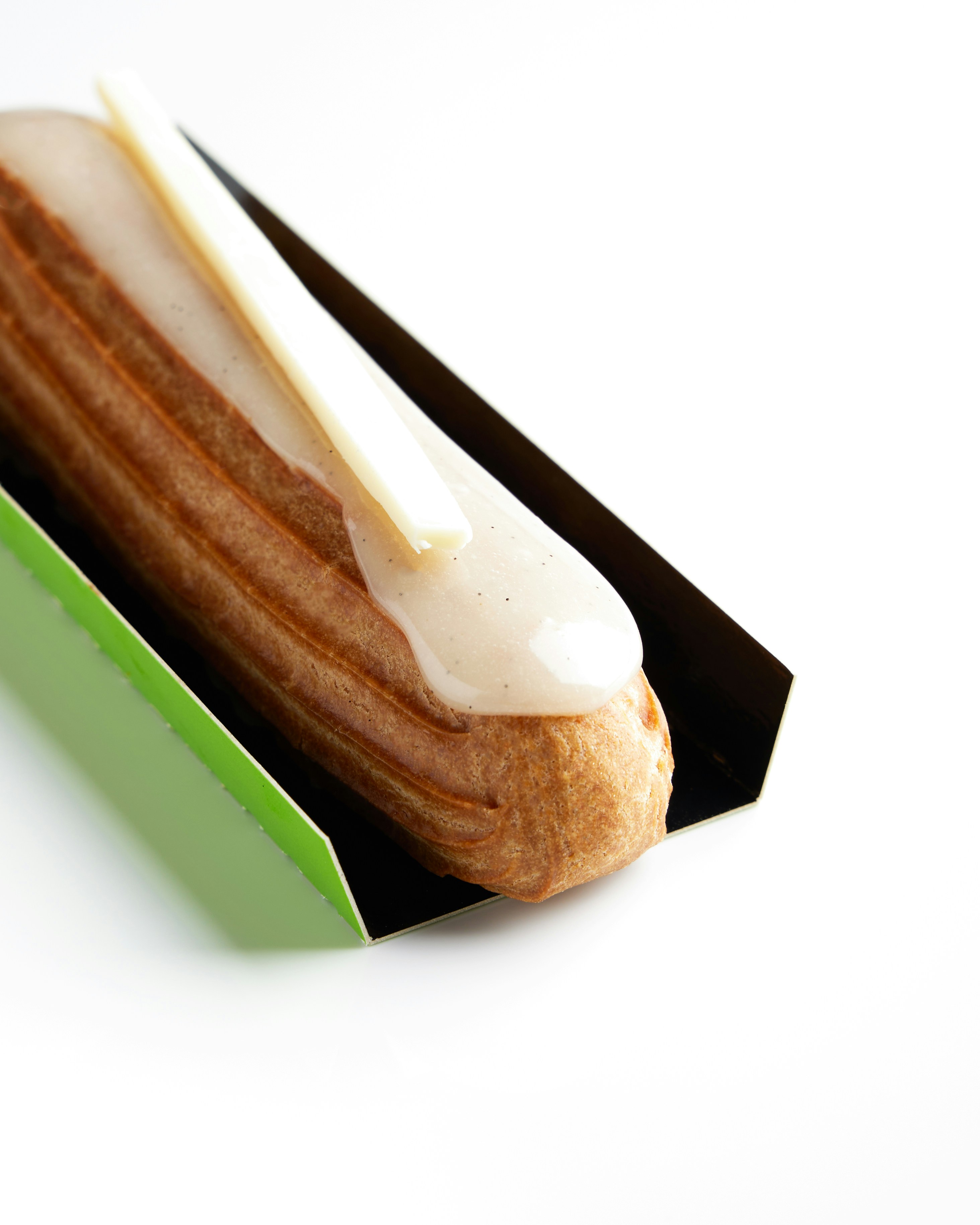 Un solo éclair coronado con un palo de chocolate blanco.