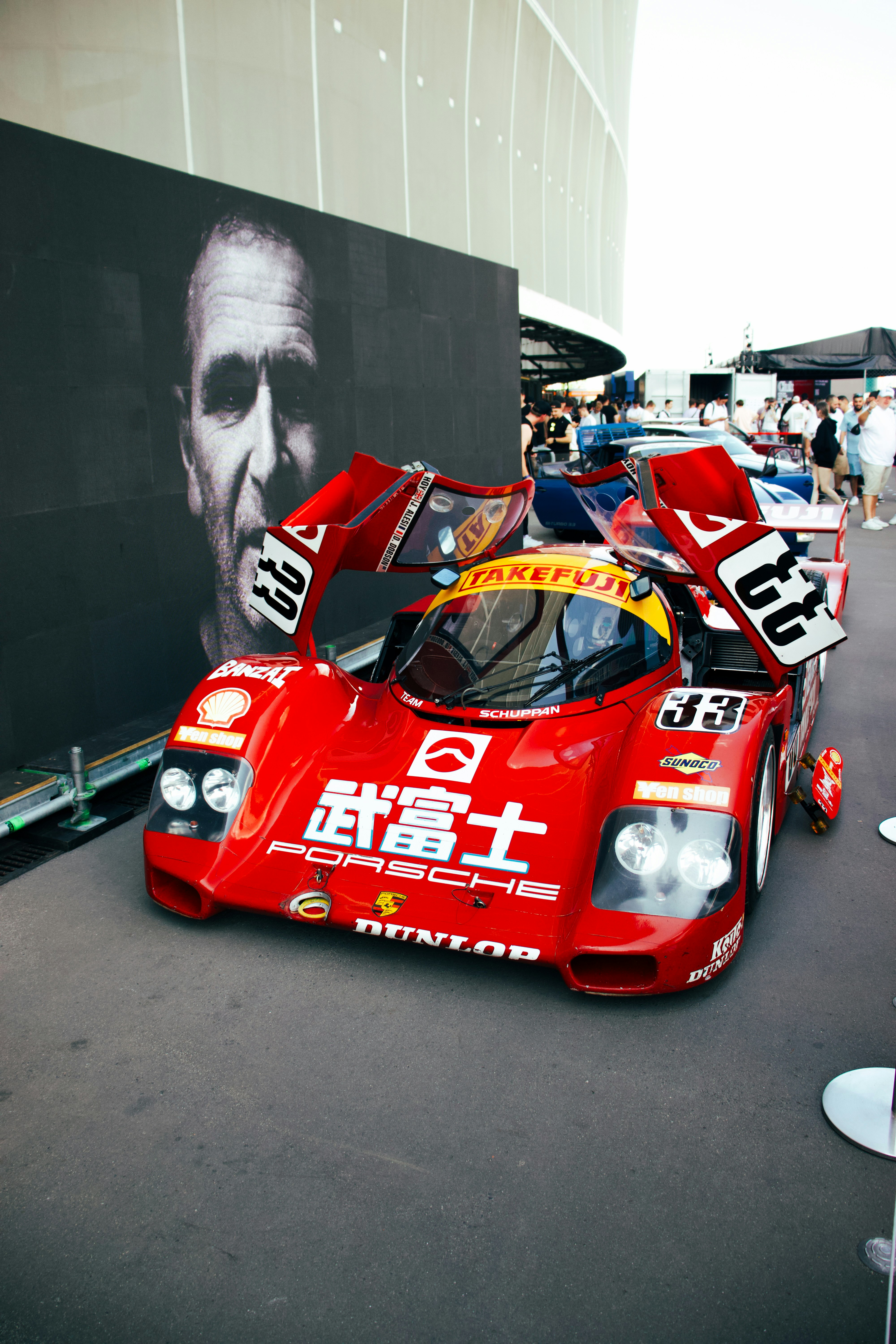 Red vintage race car with open doors and large portrait. photo – Free ...