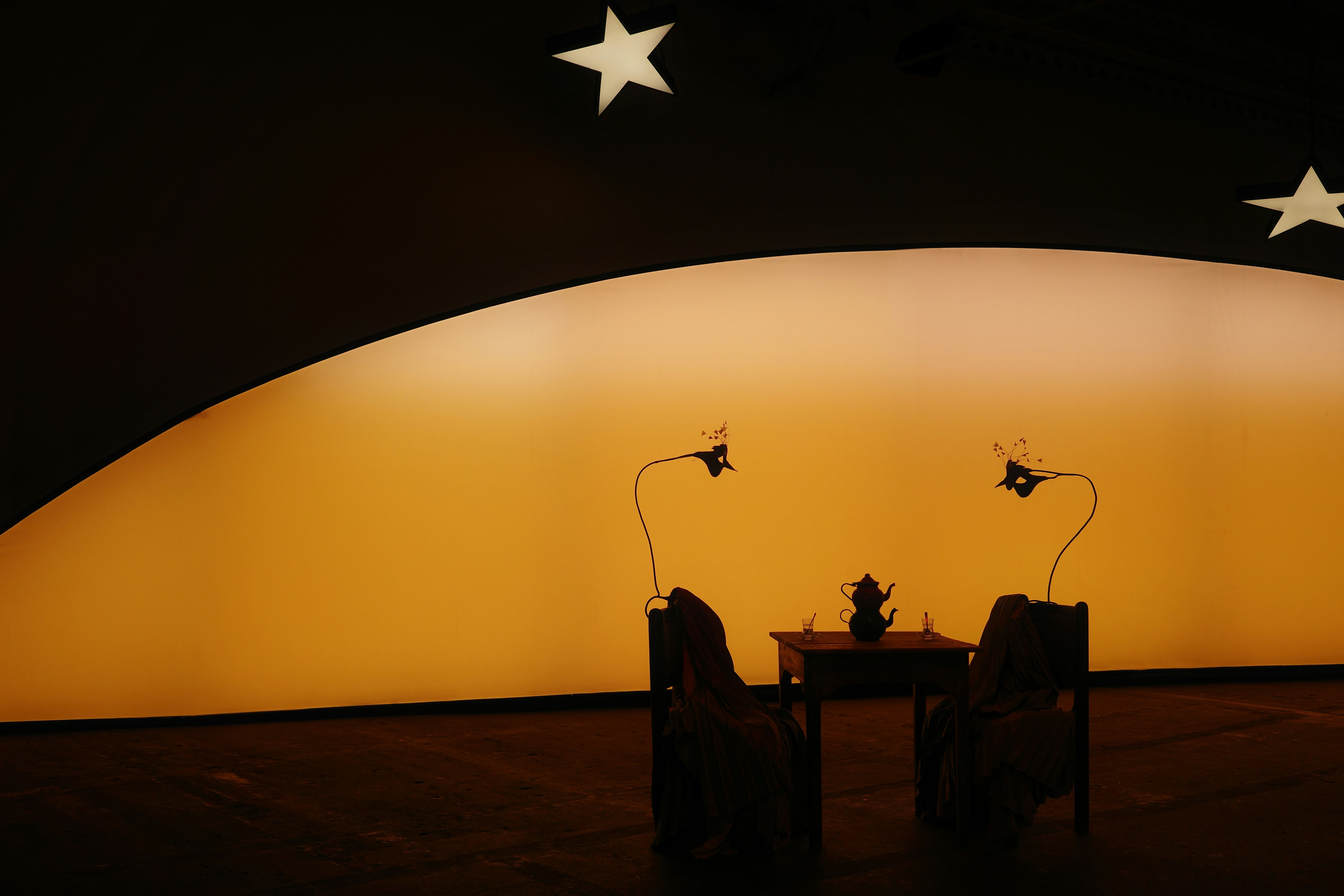 Two chairs and a table under a large orange moon.
