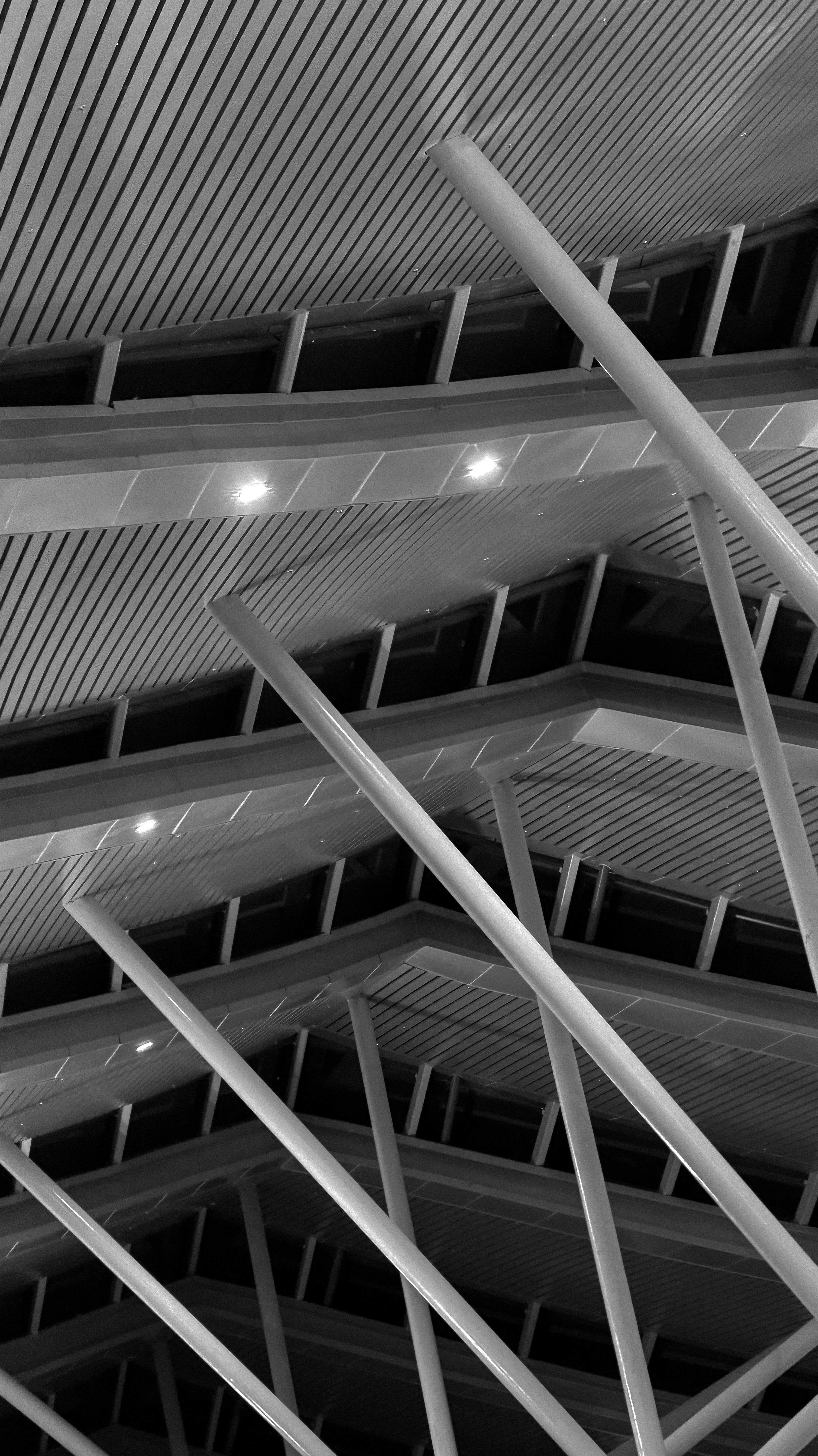 Soffitto architettonico moderno con travi bianche inclinate e luci