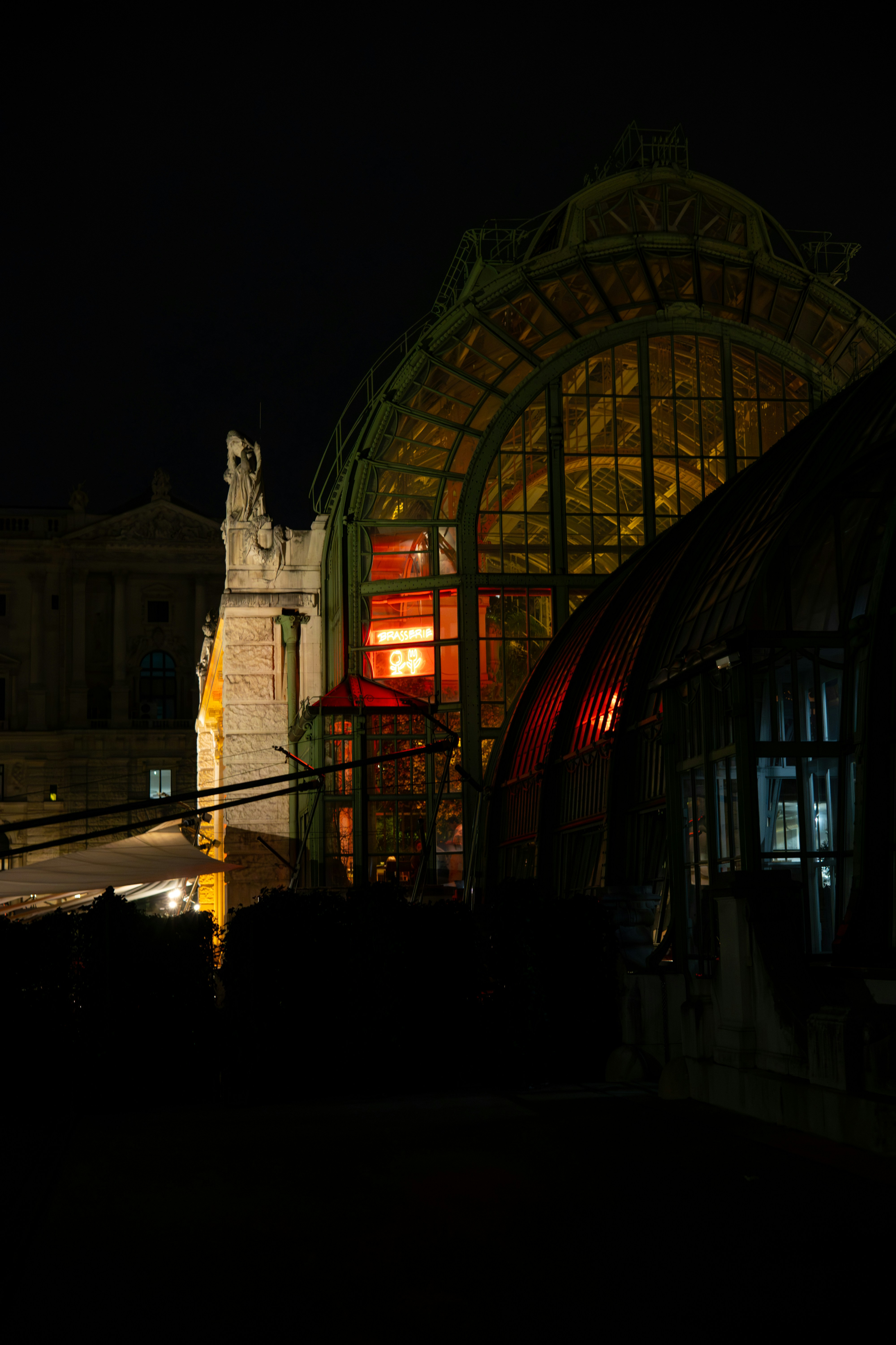 Ornate glass building illuminated with red light at night
