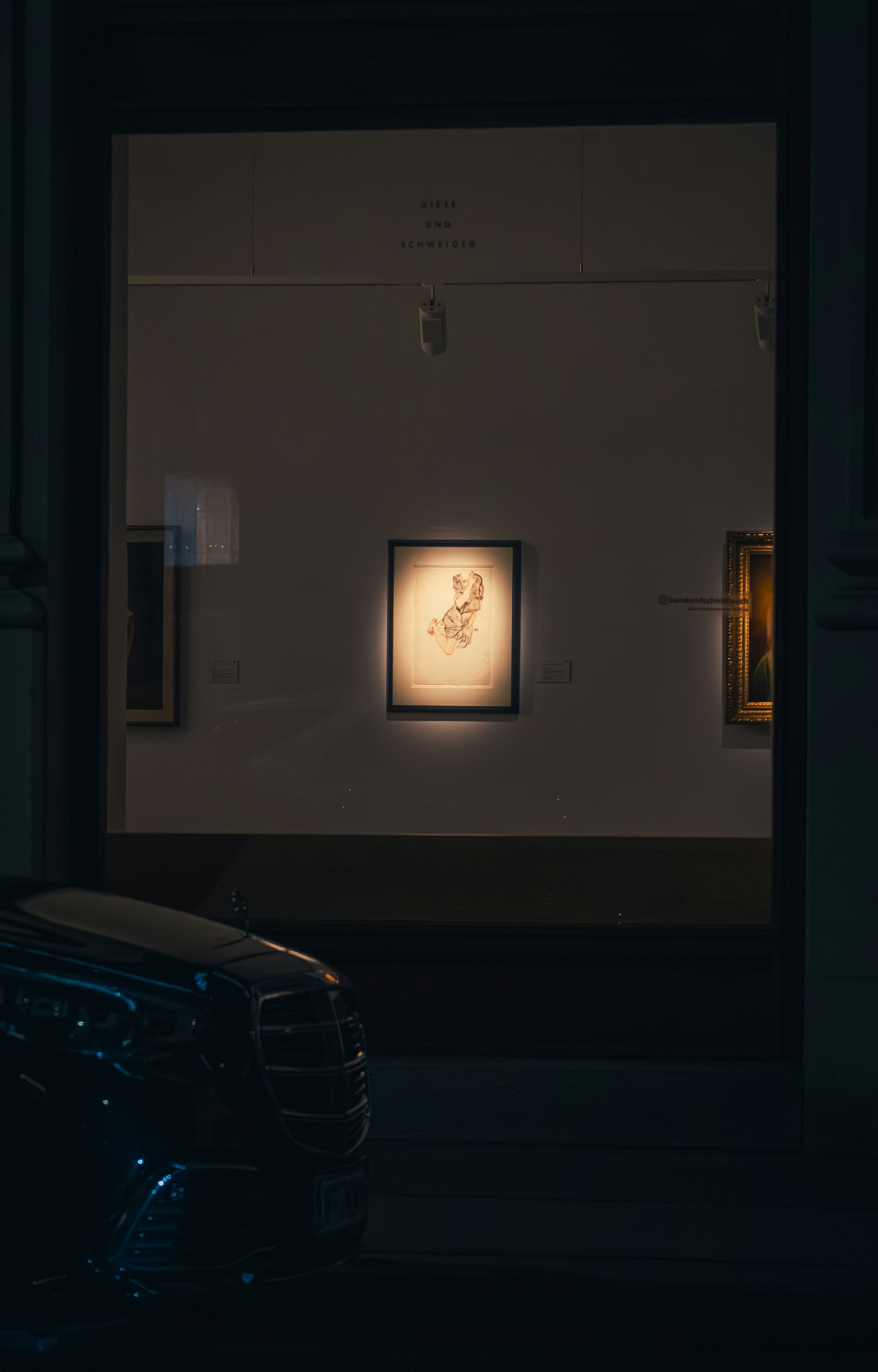Artwork displayed in a museum window at night