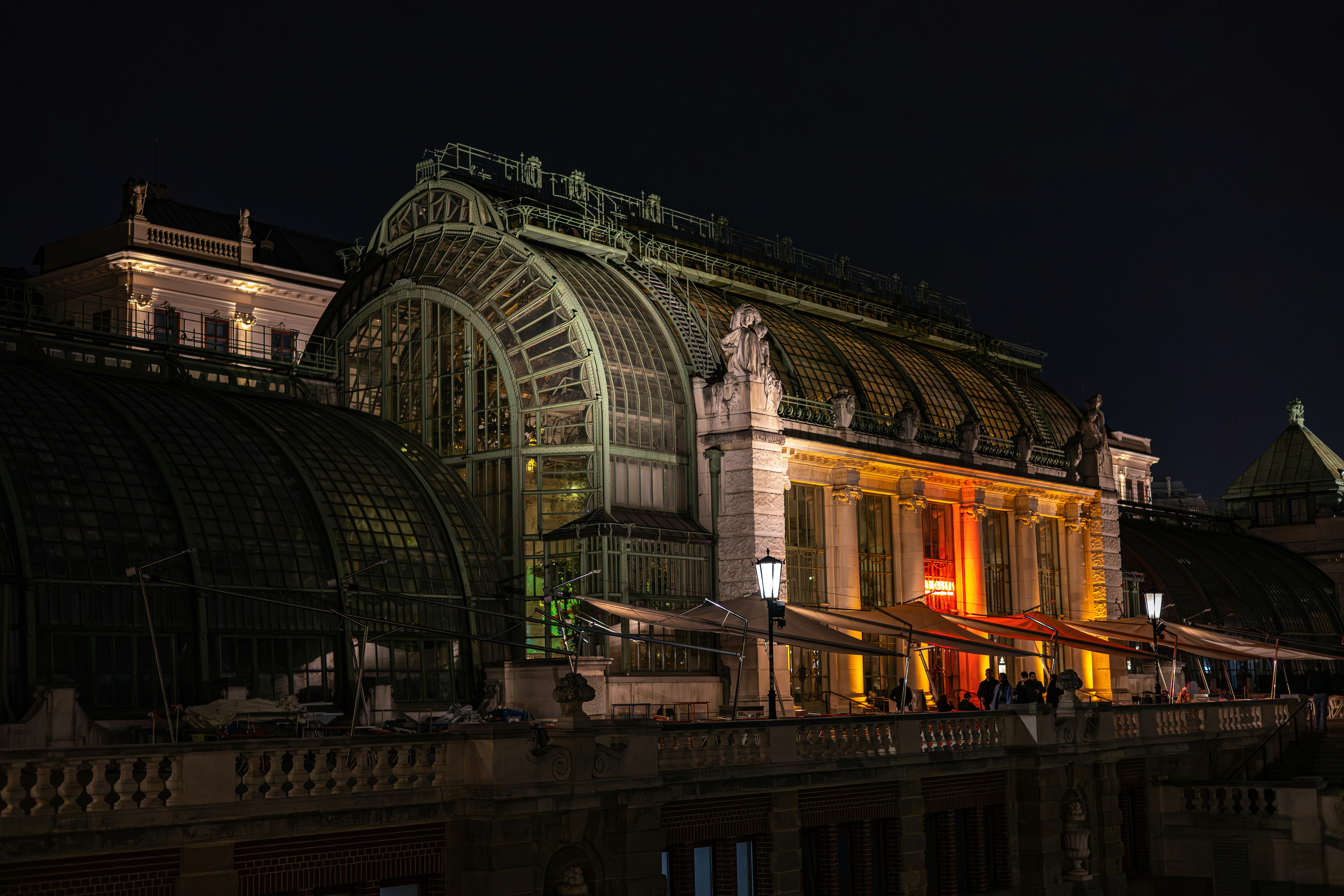 Ornate greenhouse building illuminated at night