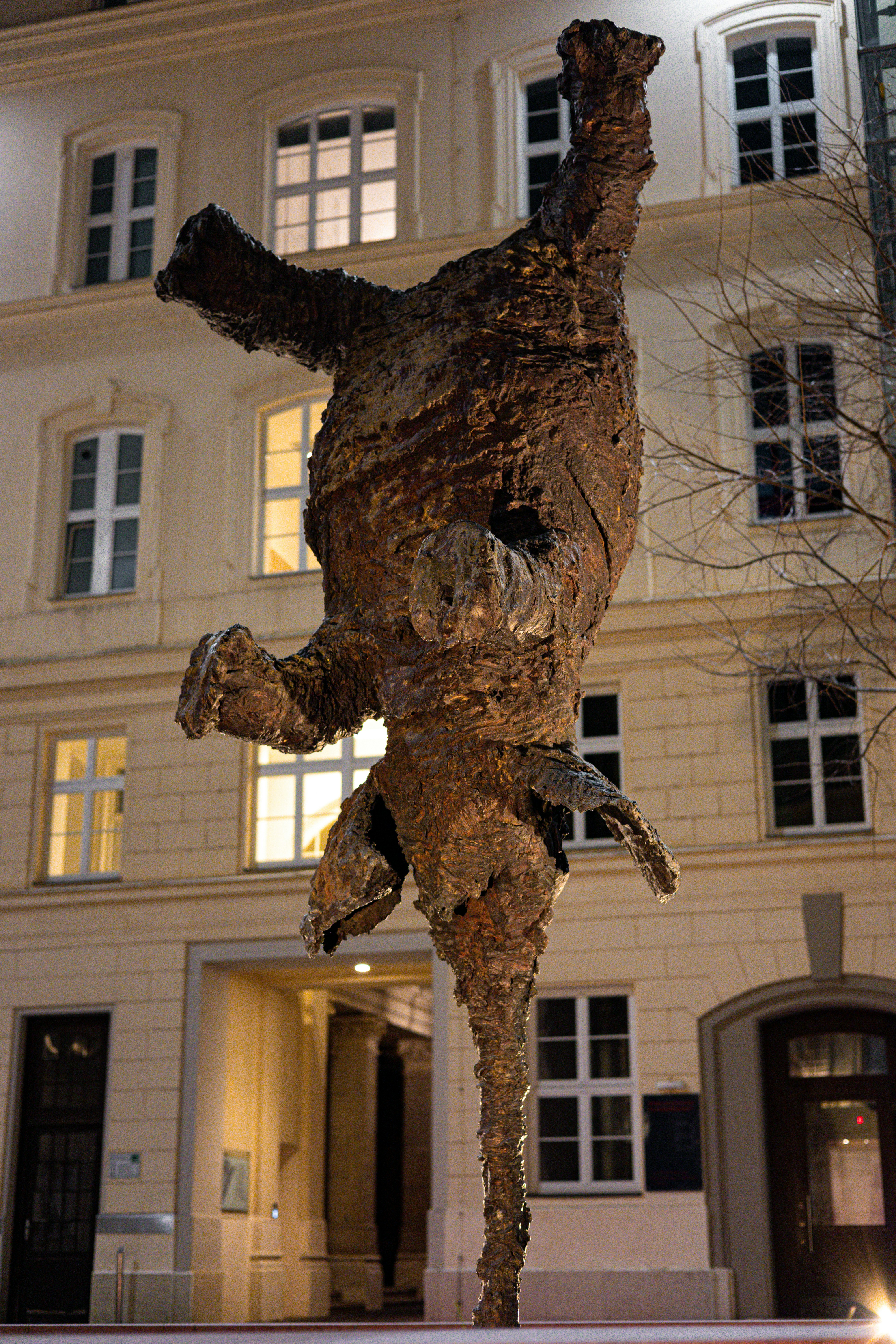 A large bronze sculpture of a bear upside down.