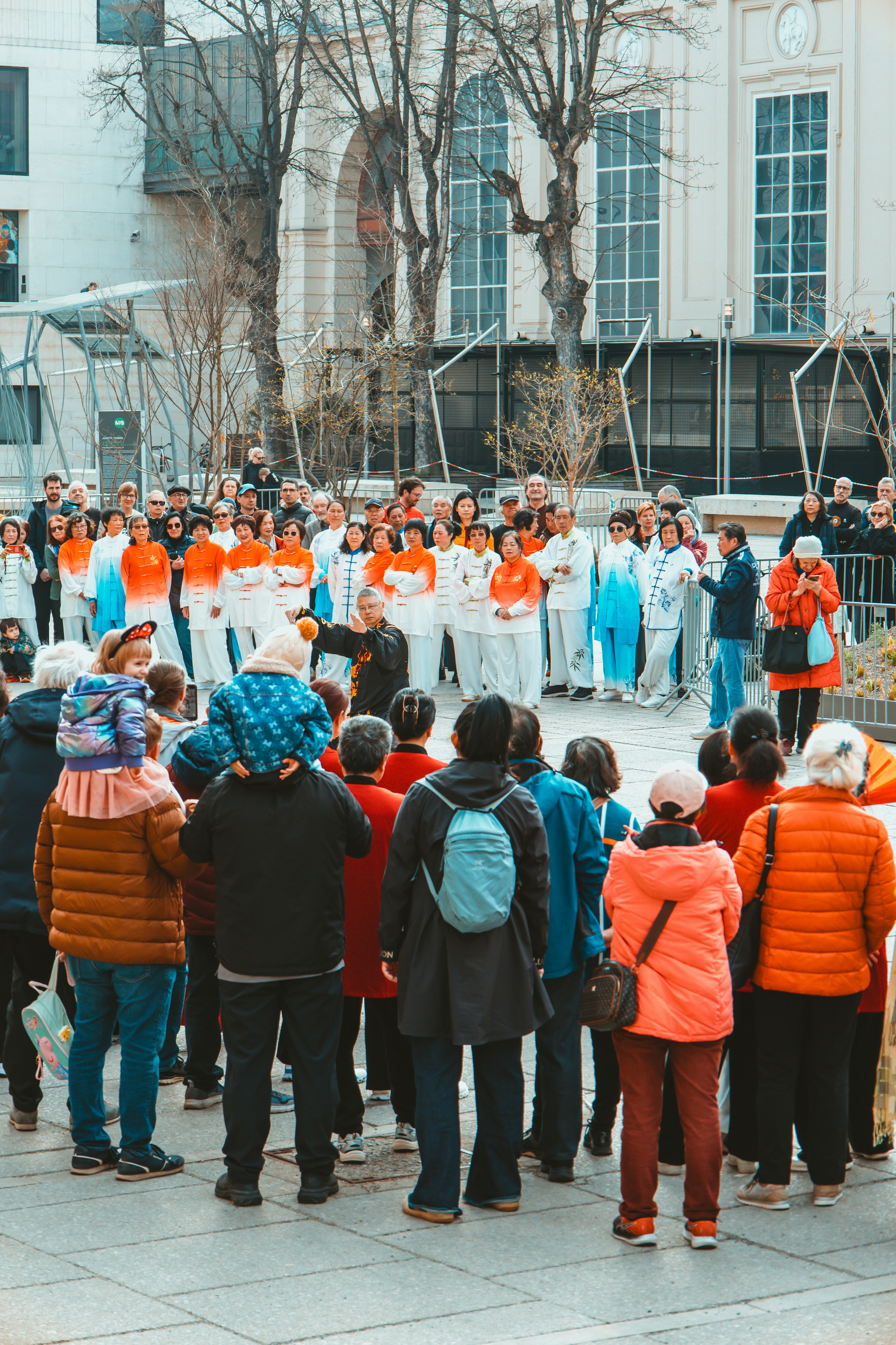 People watching a performance outdoors in a city square.
