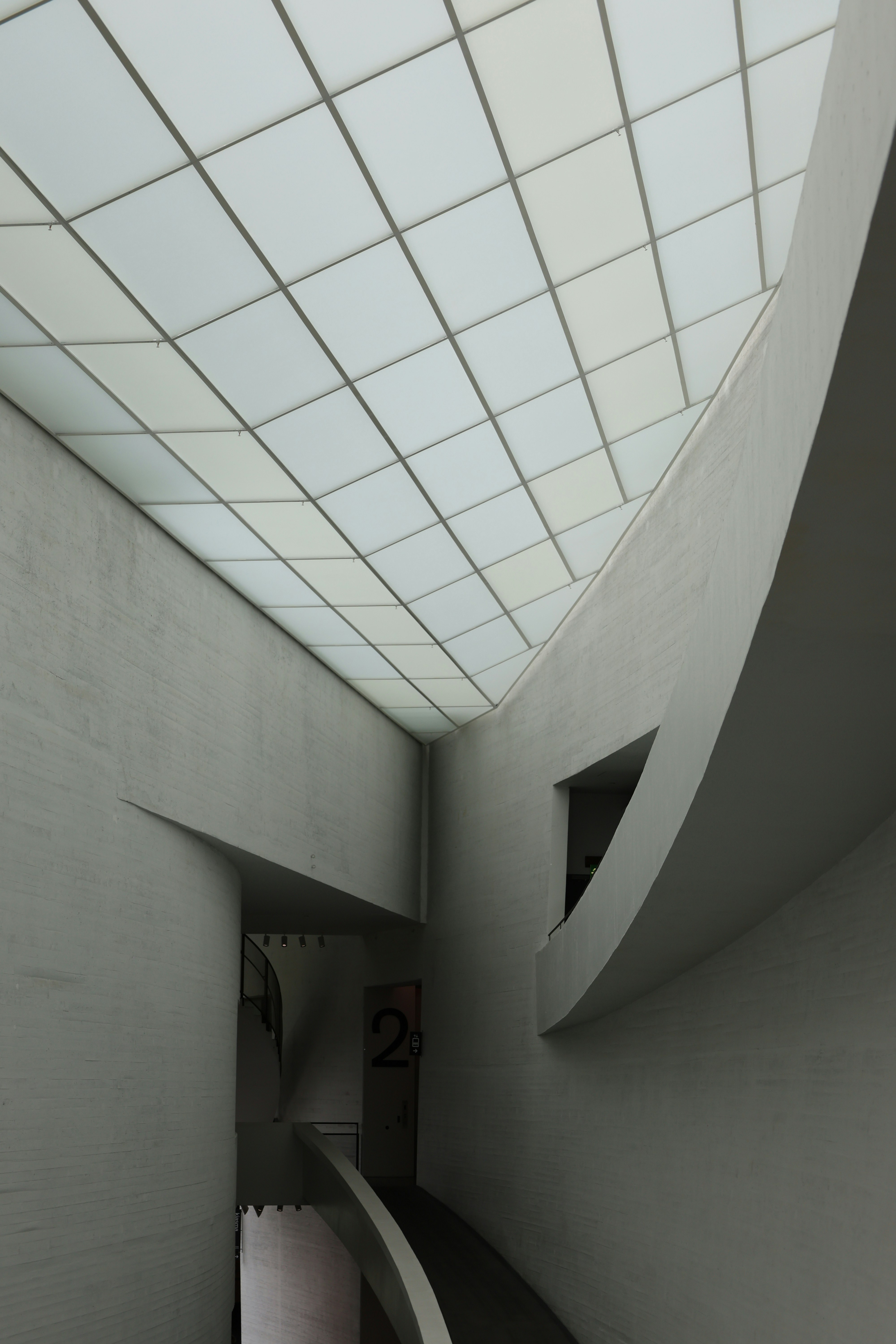 Modern building interior with geometric ceiling design.