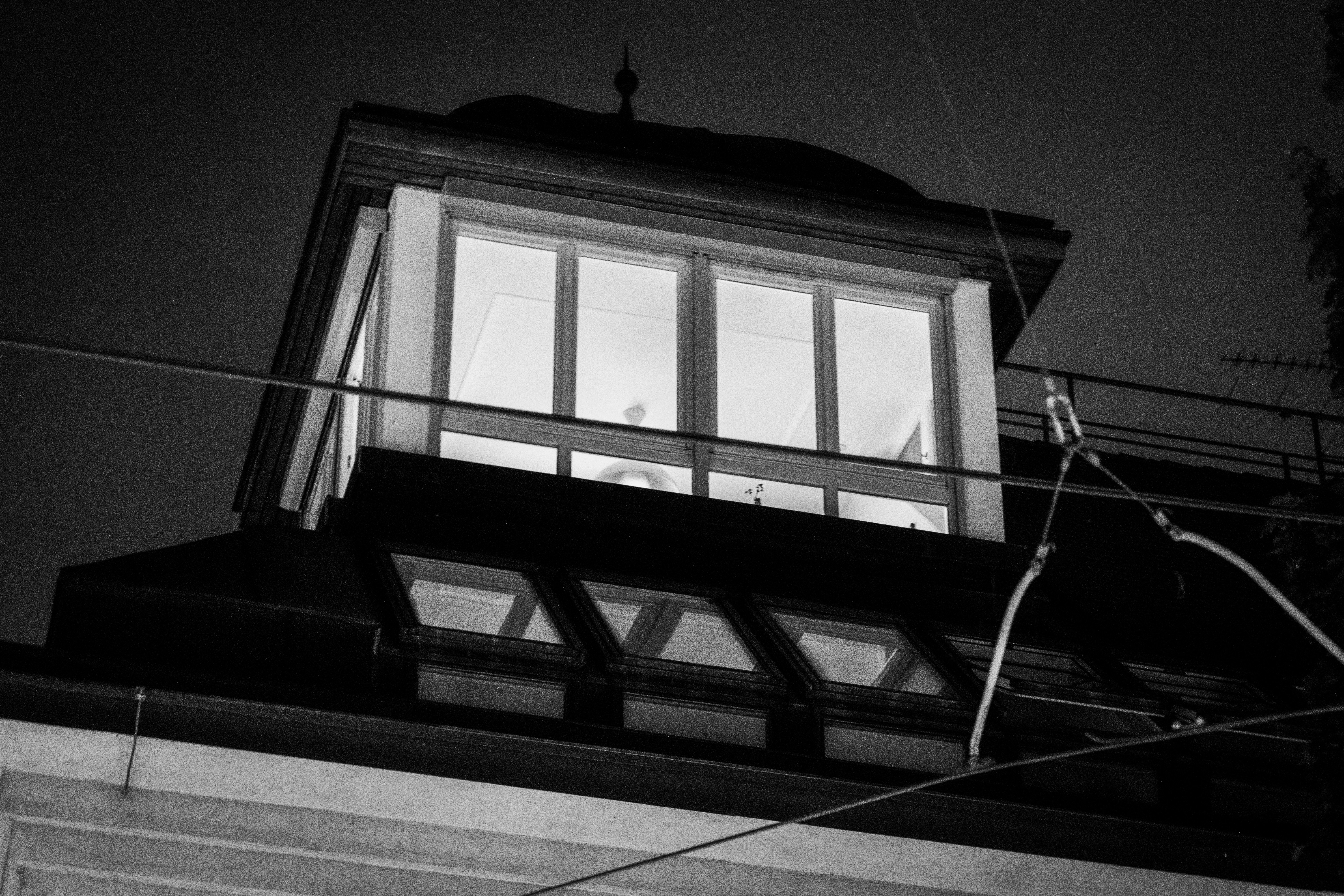Lit windows on a building roof at night