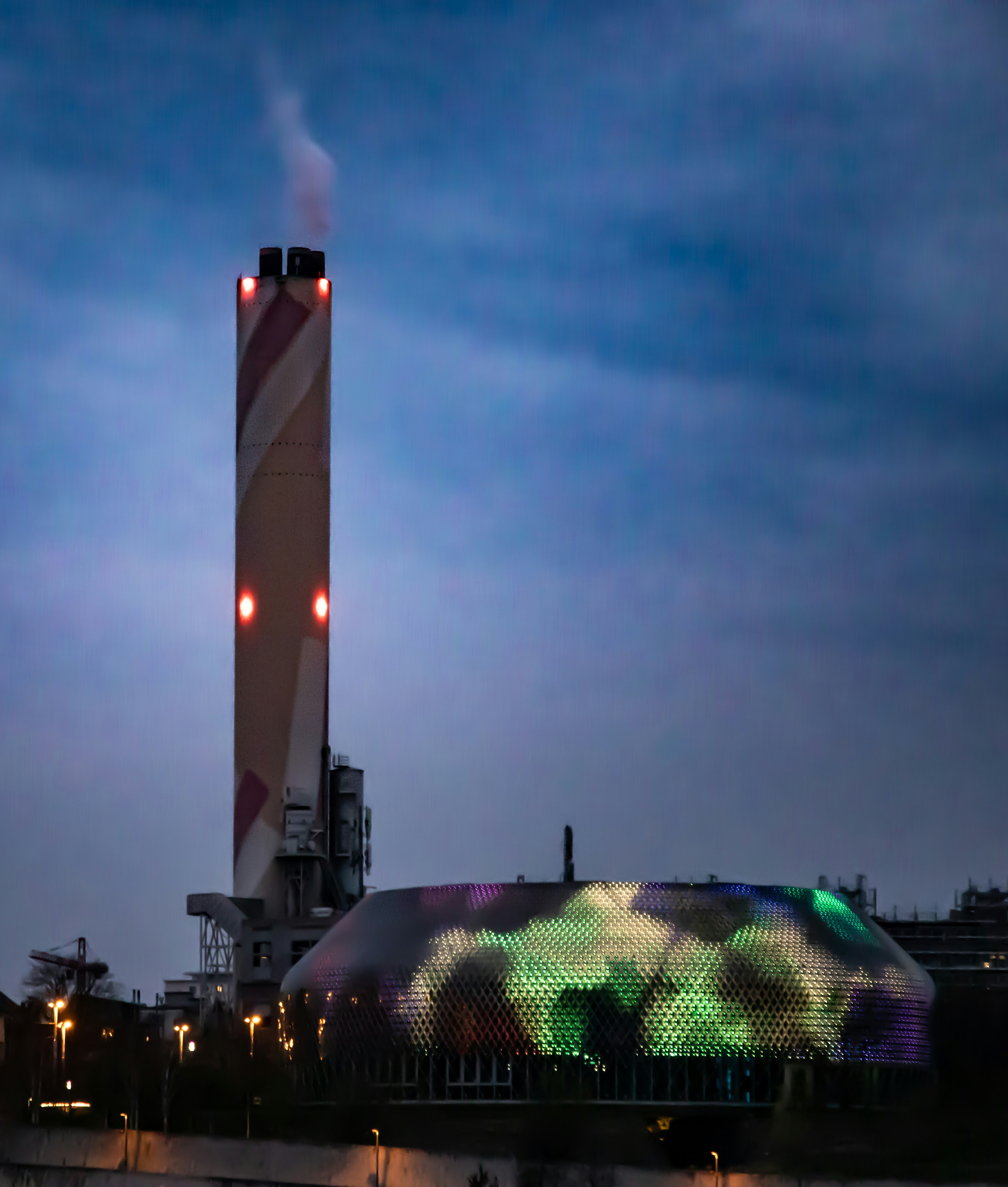 Prédio industrial com telhado iluminado e padrão e chaminé para fumaça.