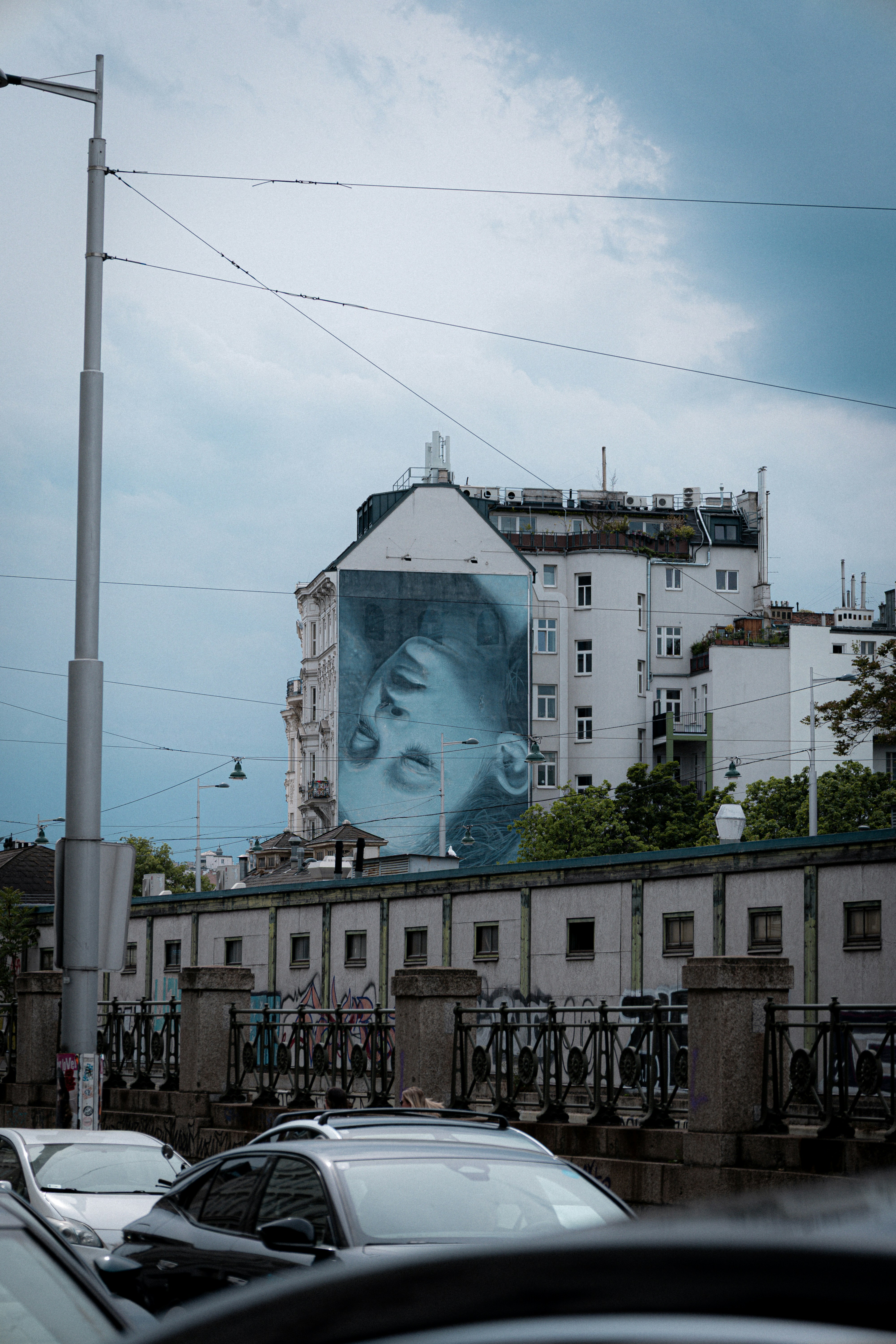 Large mural of a face on a building facade.