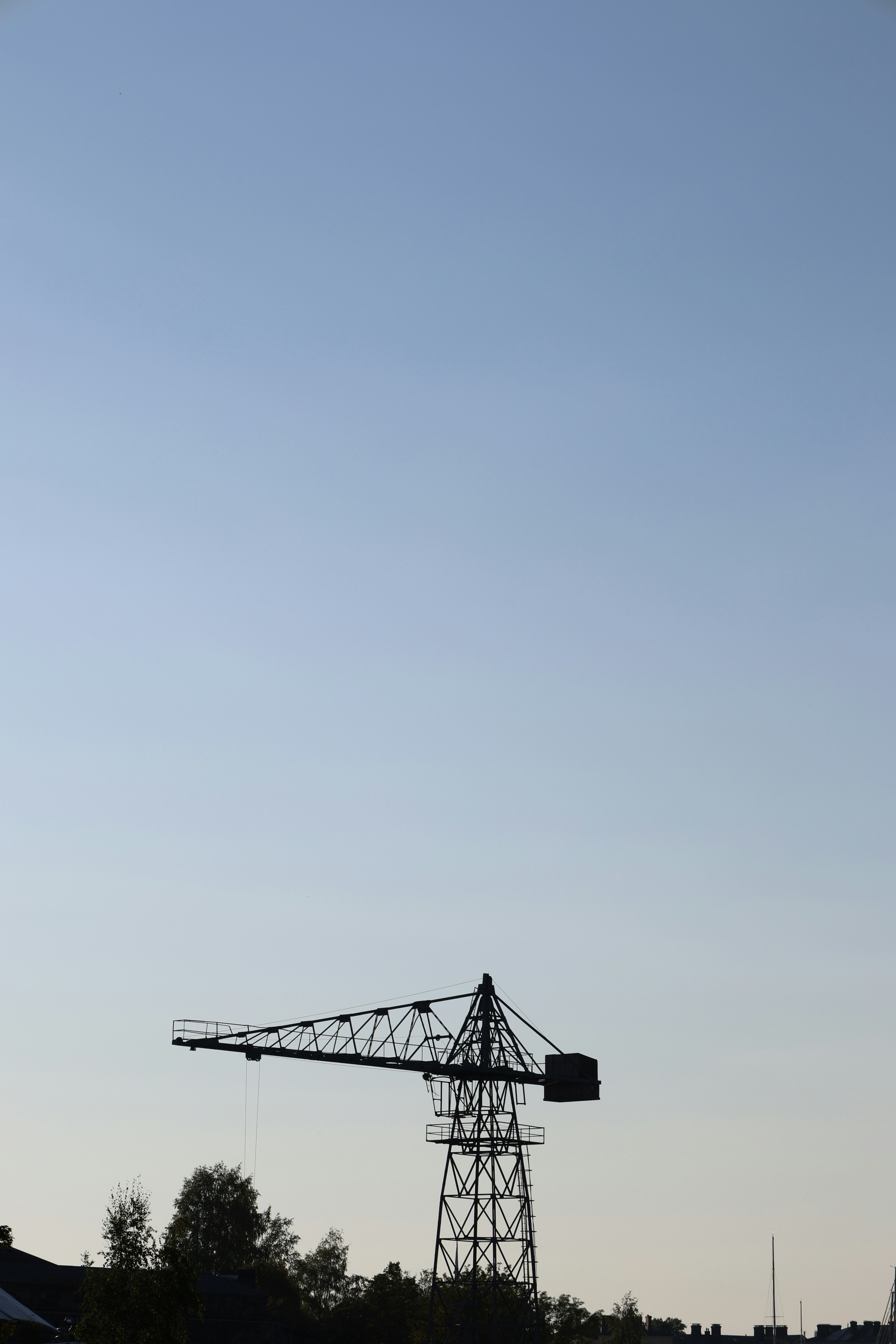 Silhouette of a construction crane against a clear sky