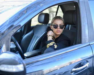 Woman with sunglasses sitting in a car.