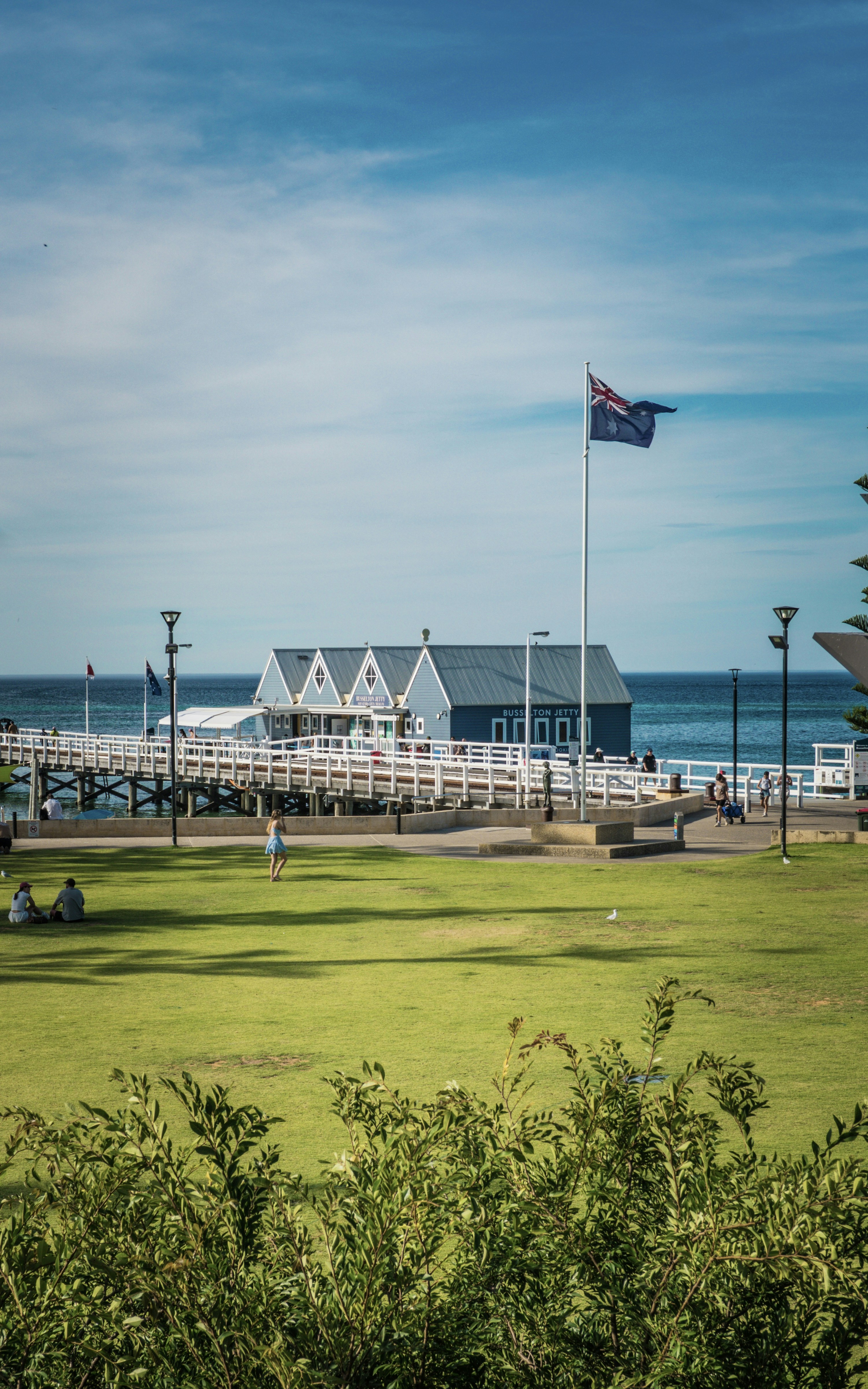 Blue building on a pier with australian flag and ocean.