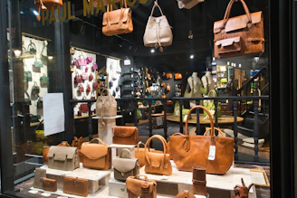 Leather handbags displayed in a retail store window.