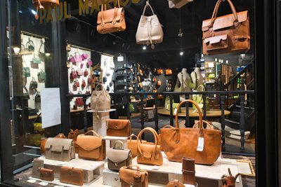 Leather handbags displayed in a retail store window.