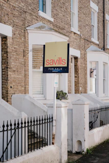 Savills for sale sign outside brick townhouses