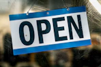 Open sign hanging on a glass door