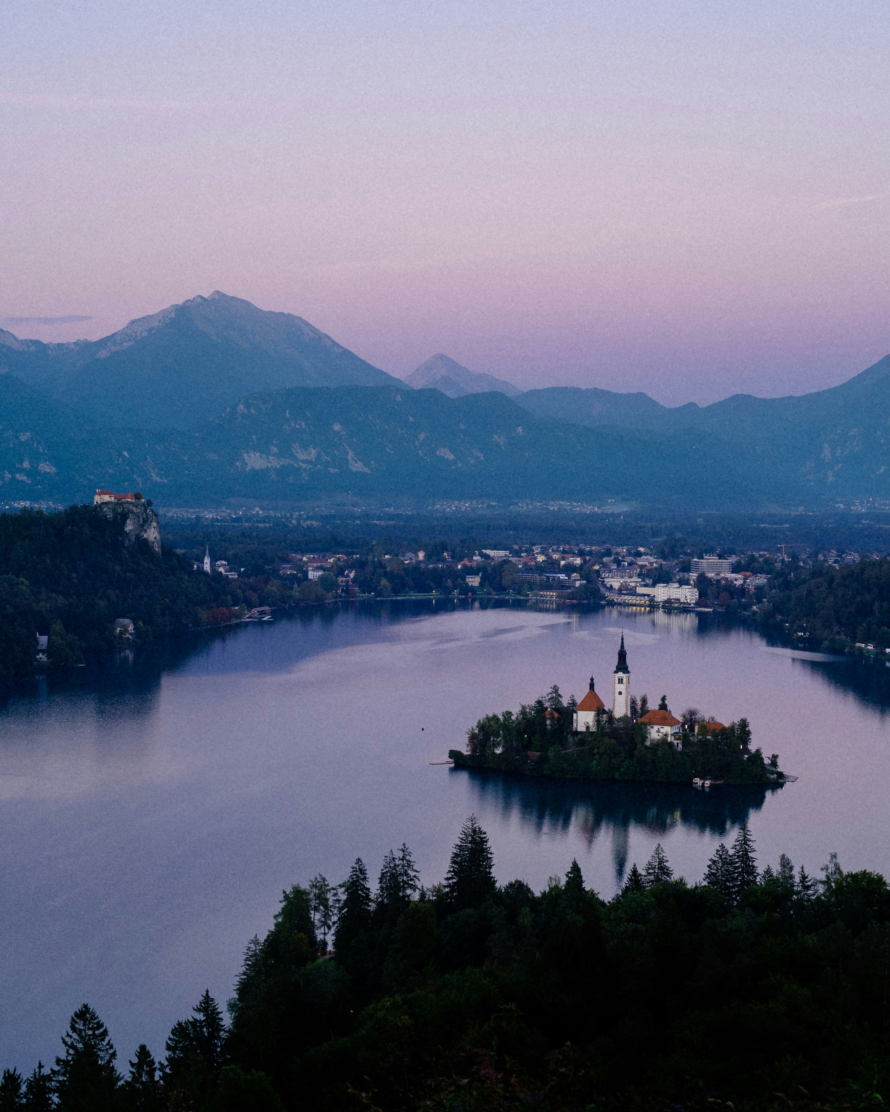 Island church on a lake with mountains at dusk