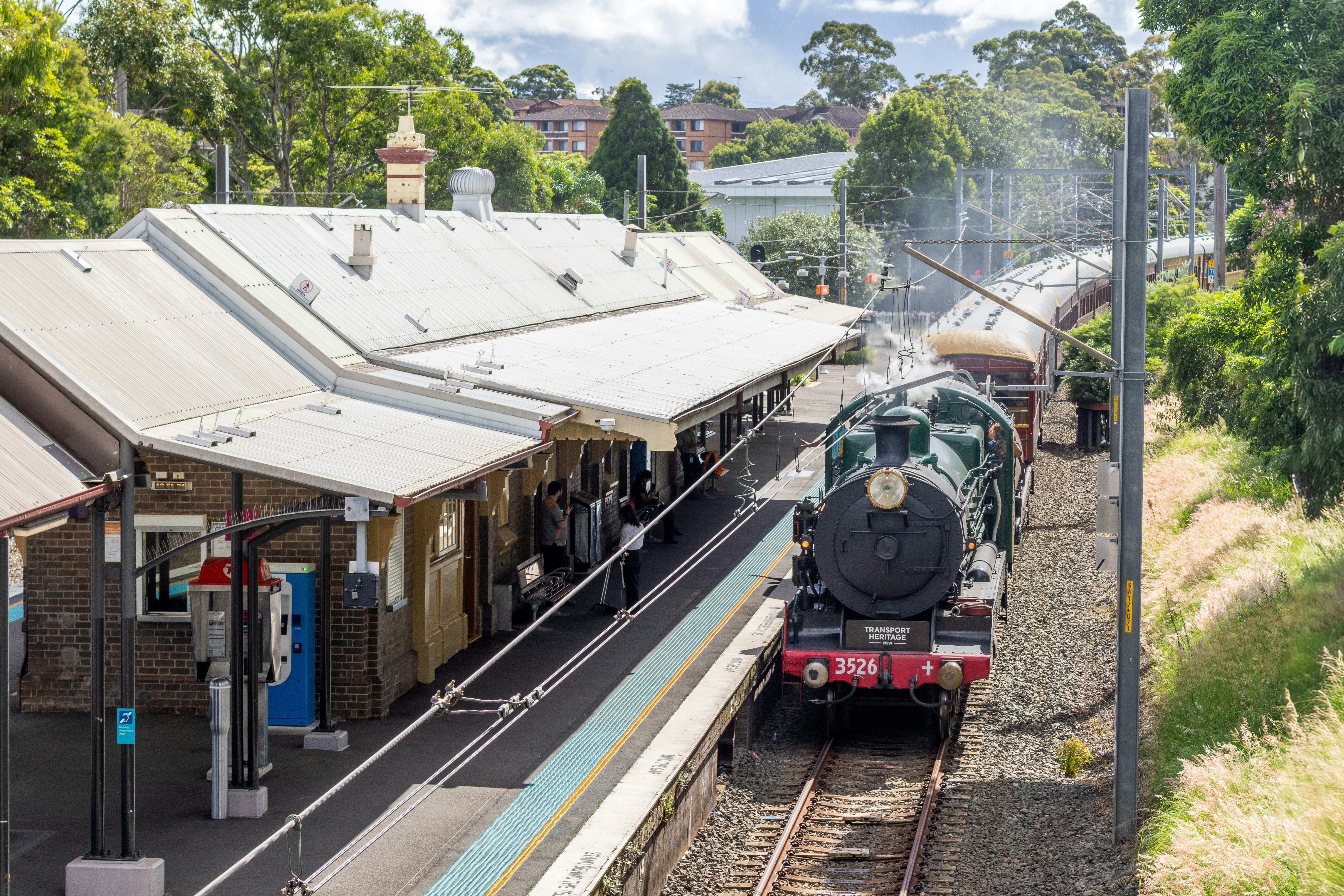 Steam train arriving at a historic station platform.