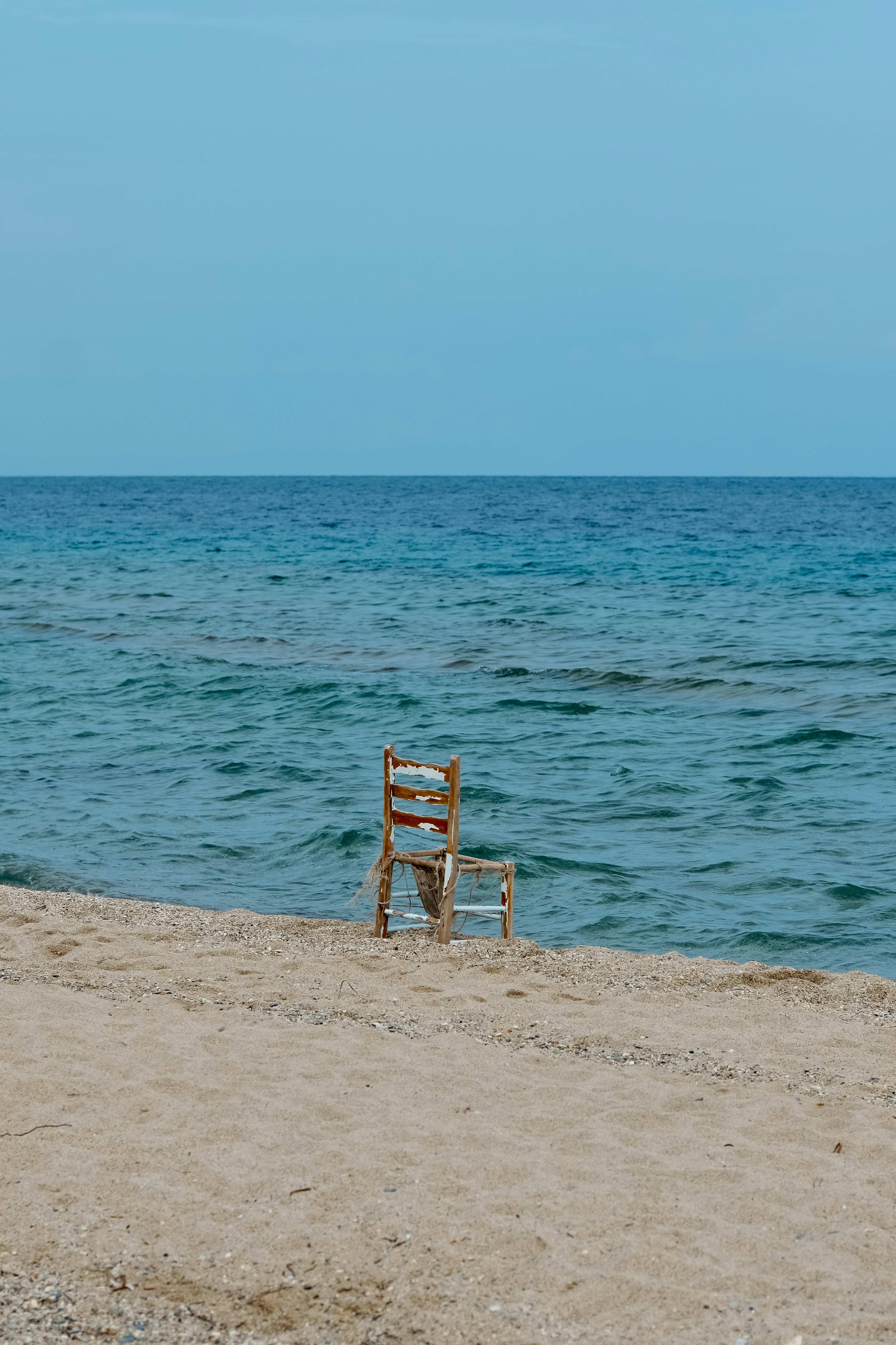Empty chair on a sandy beach by the ocean