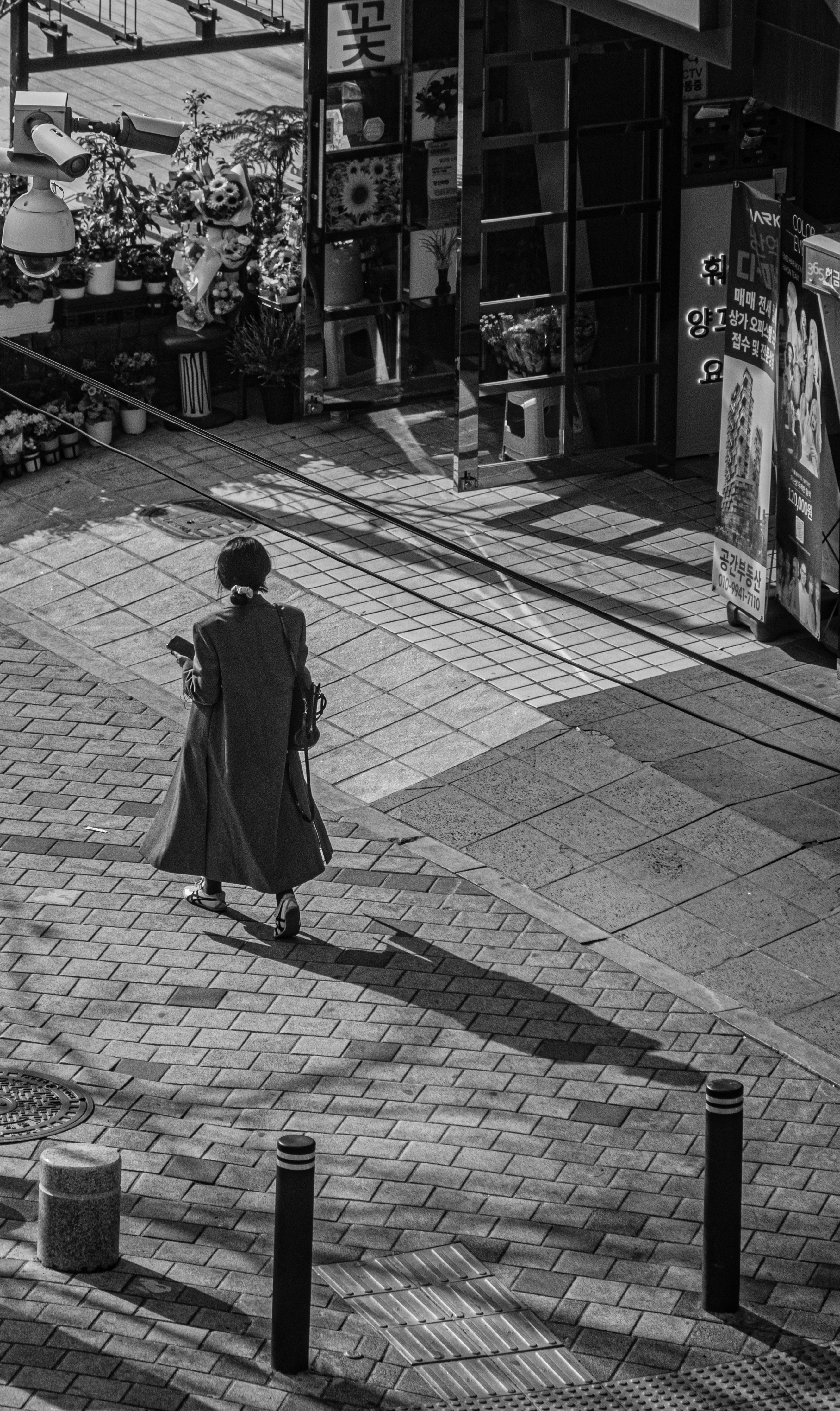 Woman walking on a sun-dappled city street