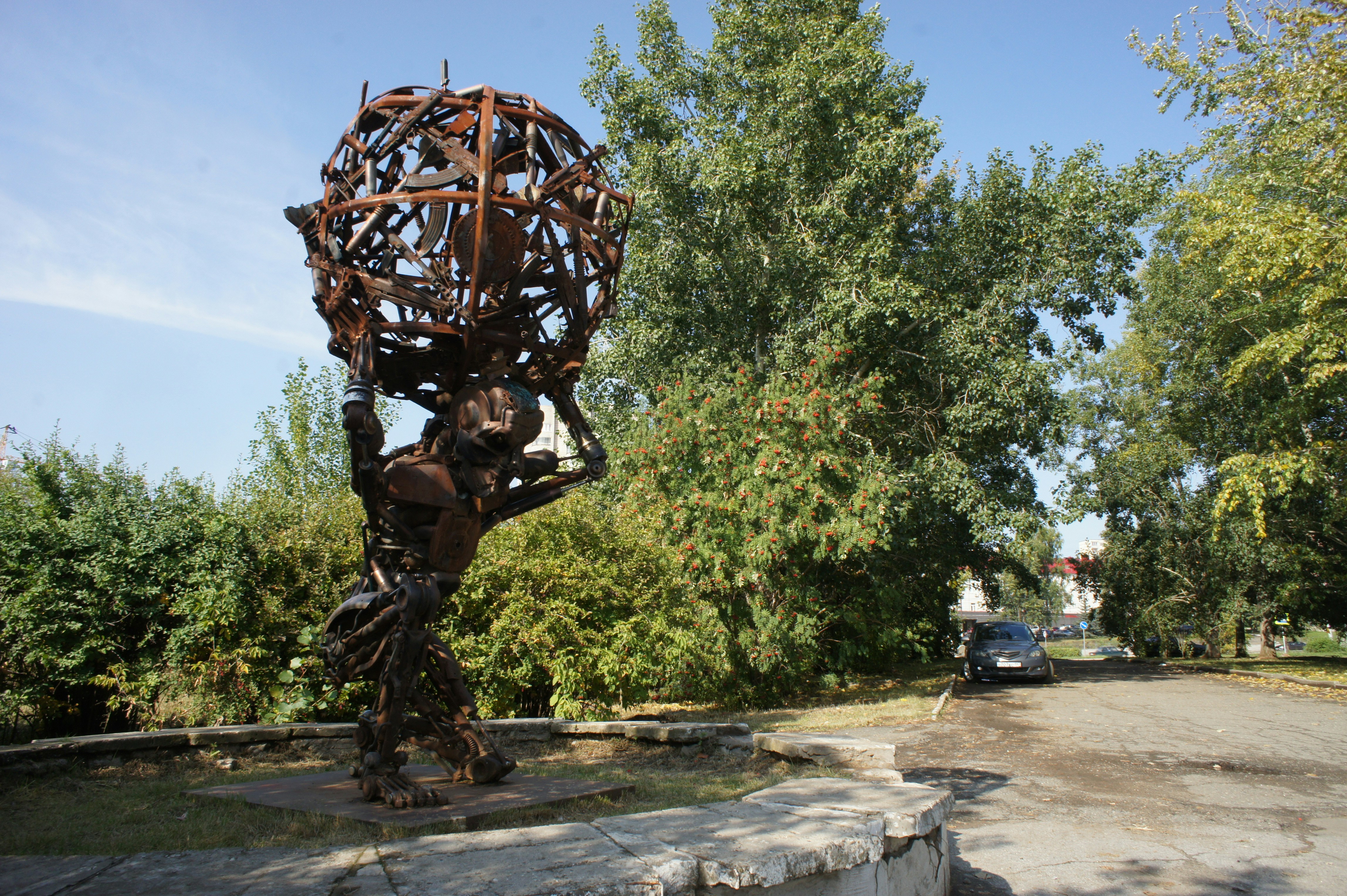 Scultura di una figura che tiene un globo all'aperto