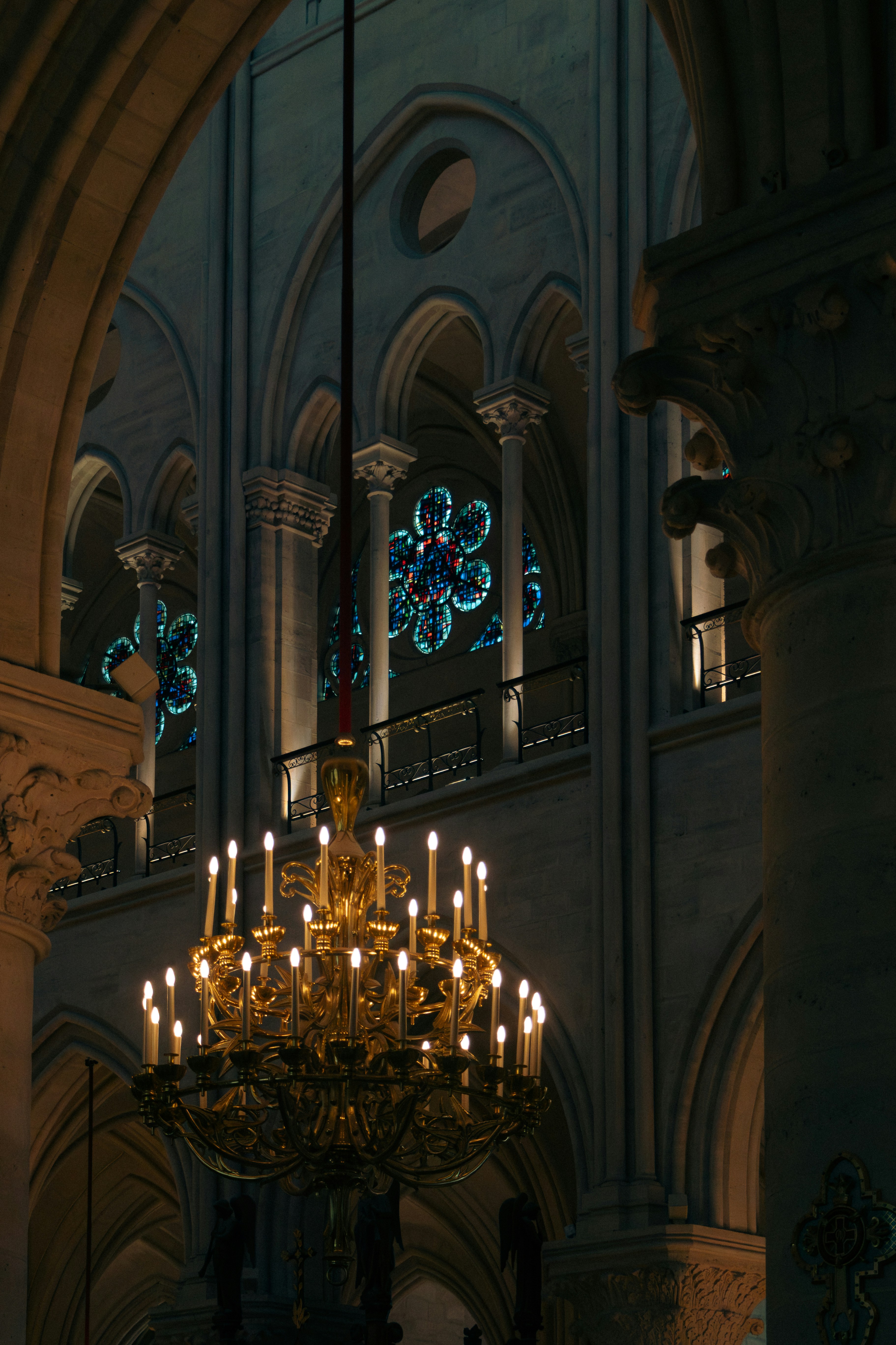 Ornate chandelier hangs in a dimly lit cathedral