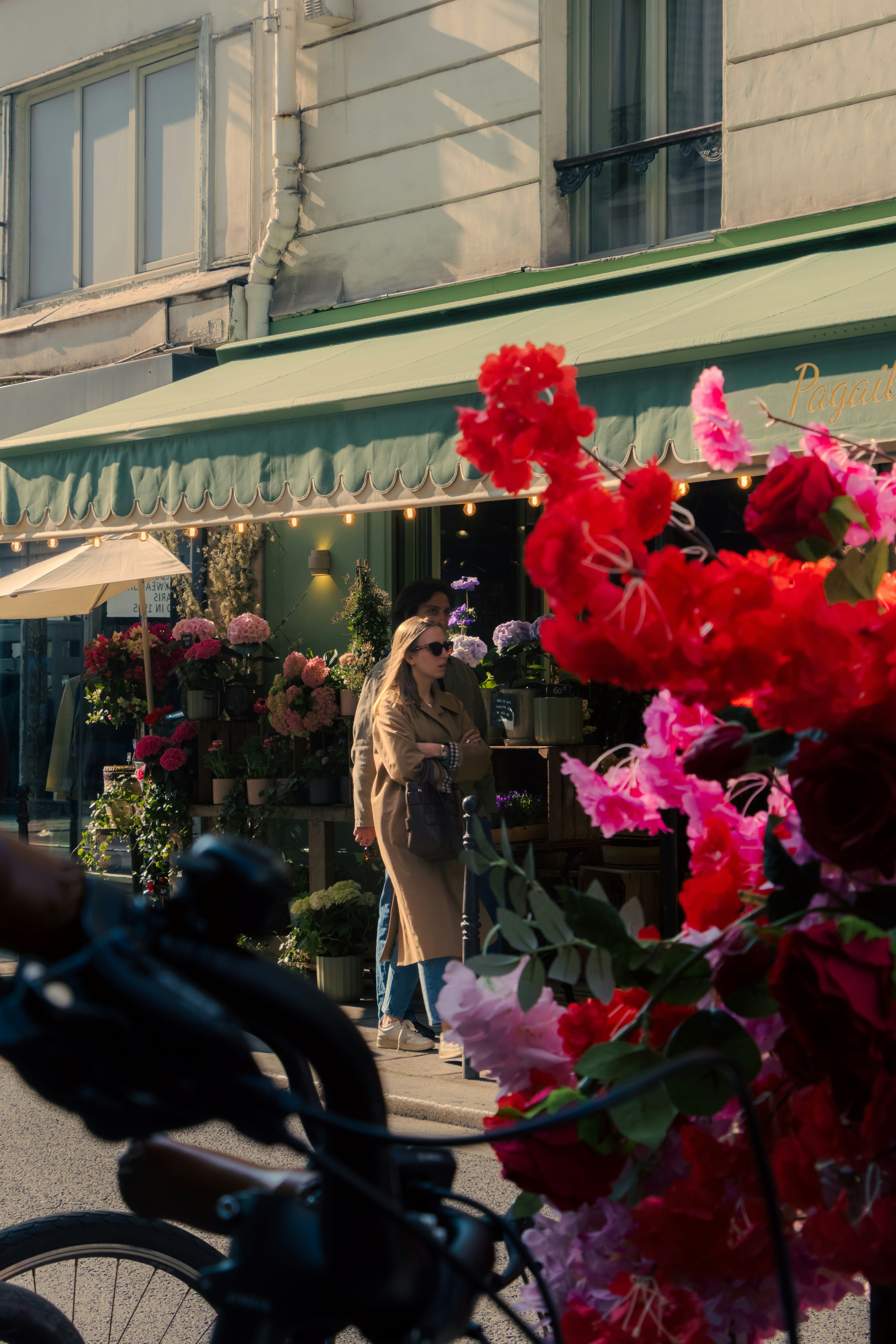 People near a flower shop with vibrant blooms